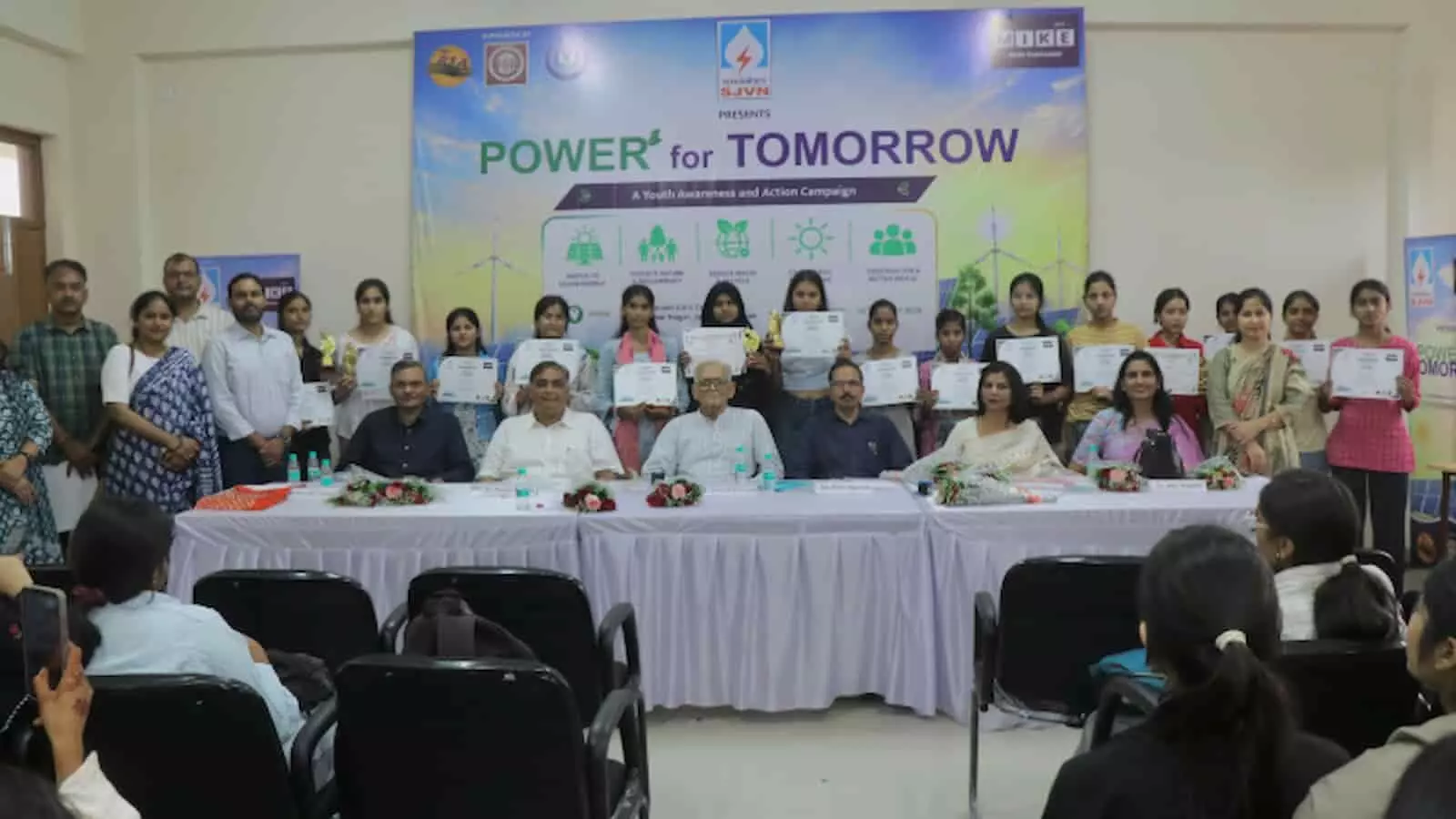 जयपुर में सौर ऊर्जा कार्यशाला के दौरान मंच पर बैठे अतिथि और प्रमाणपत्र पकड़े हुए प्रतिभागी युवा। जयपुर में सौर ऊर्जा कार्यशाला के दौरान मंच पर बैठे अतिथि और प्रमाणपत्र पकड़े हुए प्रतिभागी युवा।