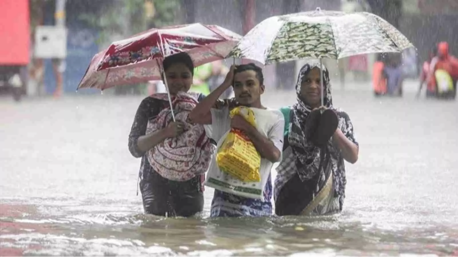 बारिश के पानी भरे रास्ते से गुजरते हुए लोग उत्तर भारत में मौसम खराब होने के संदर्भ में। बारिश के पानी भरे रास्ते से गुजरते हुए लोग उत्तर भारत में मौसम खराब होने के संदर्भ में।