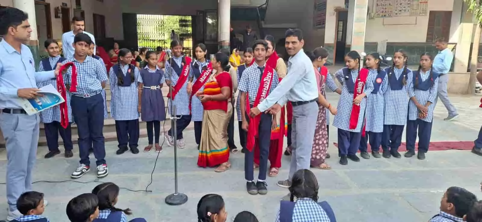 स्कूल परिसर में नवनिर्वाचित छात्र संसद पदाधिकारियों का स्वागत करते शिक्षक और खड़े विद्यार्थी। स्कूल परिसर में नवनिर्वाचित छात्र संसद पदाधिकारियों का स्वागत करते शिक्षक और खड़े विद्यार्थी।