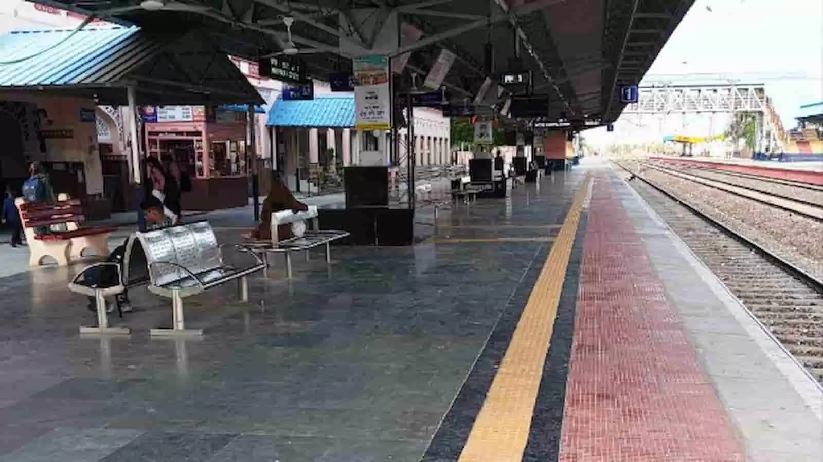 तस्वीर में रेलवे स्टेशन का प्लेटफॉर्म, बैठने के लिए बेंच और पटरियां दिखाई दे रही हैं। तस्वीर में रेलवे स्टेशन का प्लेटफॉर्म, बैठने के लिए बेंच और पटरियां दिखाई दे रही हैं।