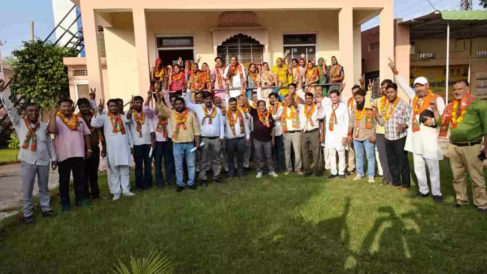 तस्वीर में भाजपा दुपट्टा पहने कार्यकर्ता और उम्मीदवार एक भवन के सामने हाथ उठाकर खड़े हैं। तस्वीर में भाजपा दुपट्टा पहने कार्यकर्ता और उम्मीदवार एक भवन के सामने हाथ उठाकर खड़े हैं।