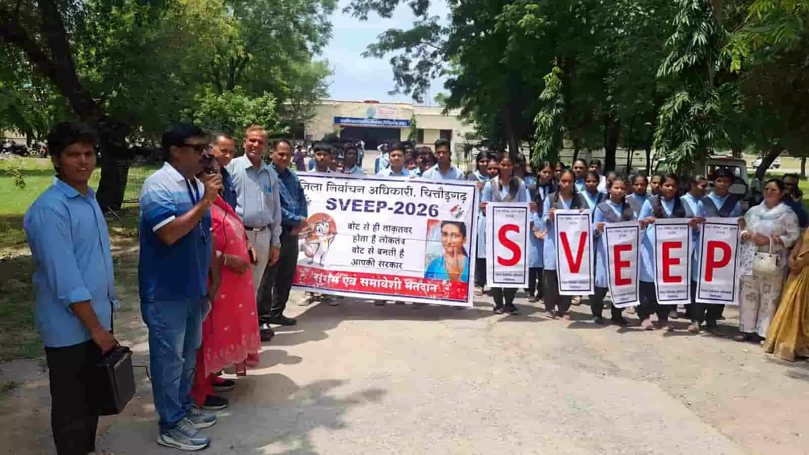 तस्वीर में चित्तौड़गढ़ में मतदाता जागरूकता रैली के दौरान बैनर और पोस्टर पकड़े खड़े विद्यार्थी और अधिकारी। तस्वीर में चित्तौड़गढ़ में मतदाता जागरूकता रैली के दौरान बैनर और पोस्टर पकड़े खड़े विद्यार्थी और अधिकारी।