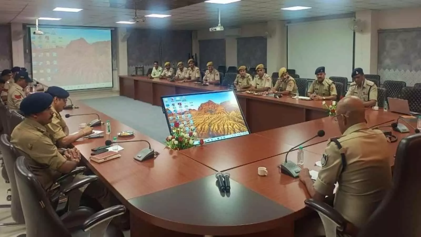 तस्वीर में दिख रही पुलिस टीम एक बड़ी मेज के चारों ओर बैठकर बैठक में चर्चा कर रही है। तस्वीर में दिख रही पुलिस टीम एक बड़ी मेज के चारों ओर बैठकर बैठक में चर्चा कर रही है।
