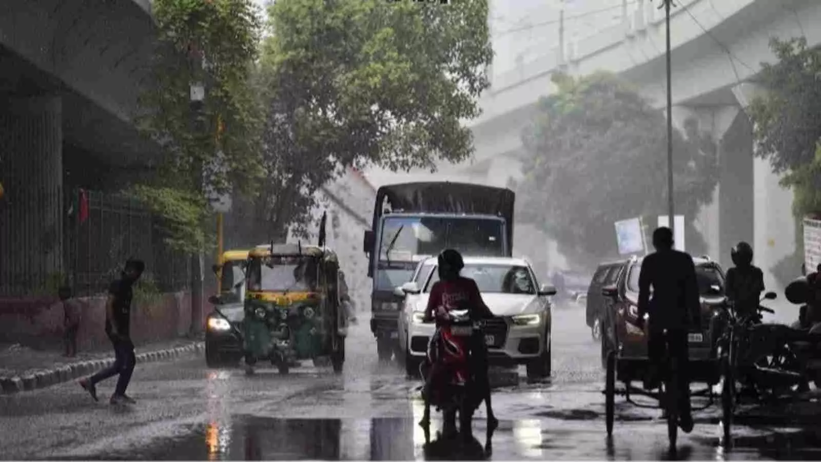 बारिश के दौरान दिल्ली की सड़क पर वाहन चलाते लोग और चलते राहगीर| बारिश के दौरान दिल्ली की सड़क पर वाहन चलाते लोग और चलते राहगीर|