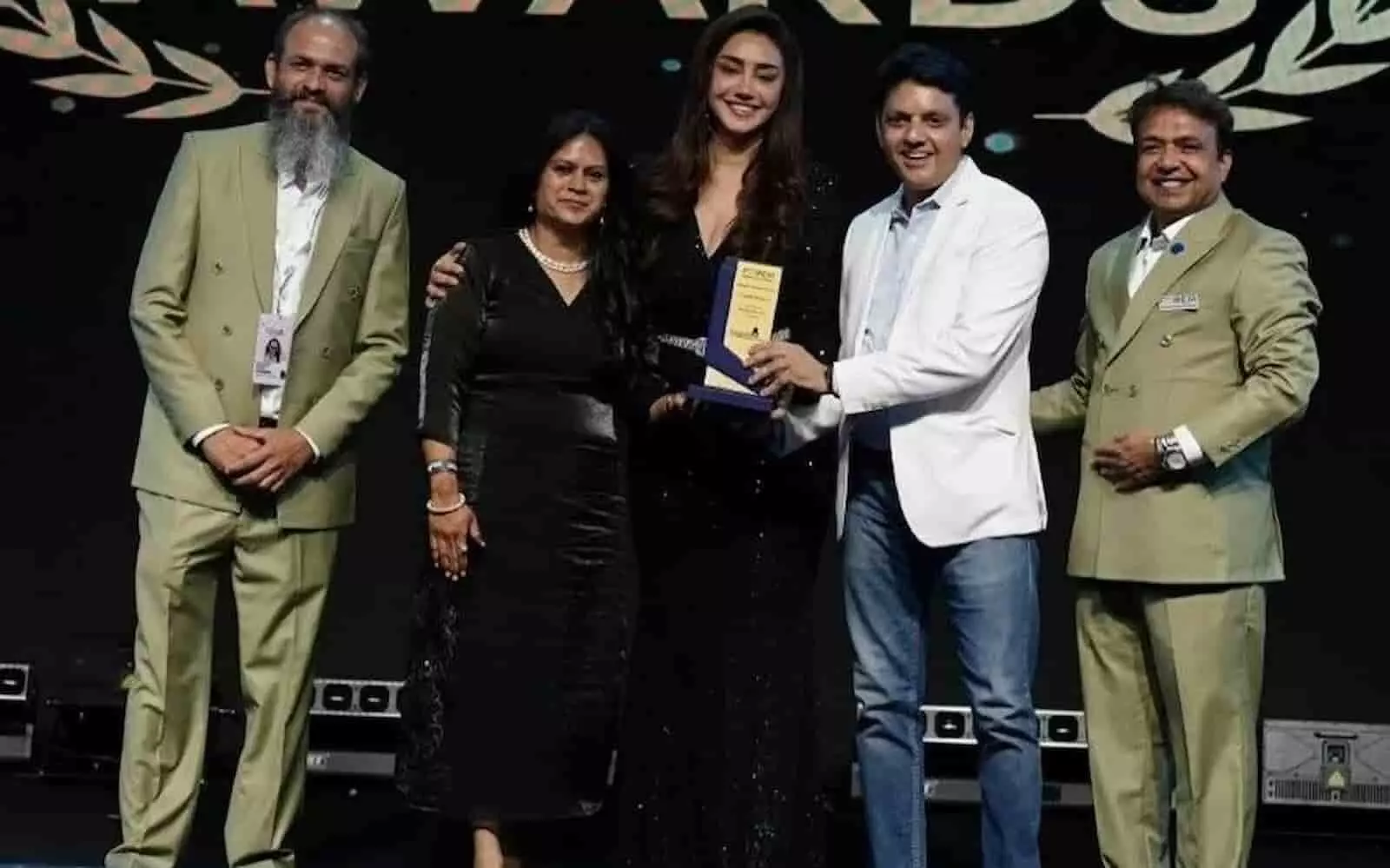 तस्वीर में बाएं से दाएं खड़े लोग, जिनमें बीच में अभिनेत्री महक चहल एक व्यक्ति को अवॉर्ड दे रही हैं। तस्वीर में बाएं से दाएं खड़े लोग, जिनमें बीच में अभिनेत्री महक चहल एक व्यक्ति को अवॉर्ड दे रही हैं।