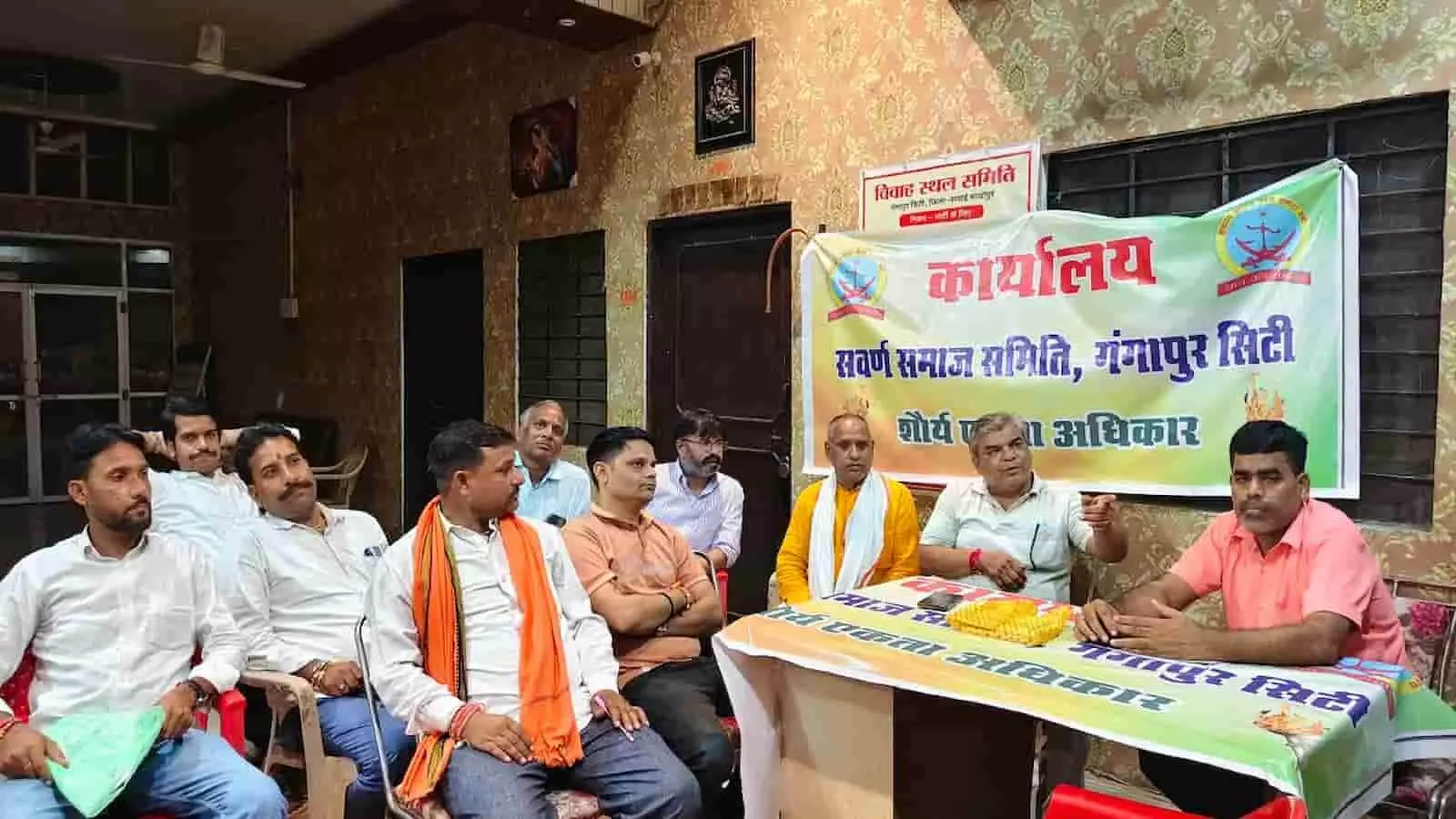 तस्वीर में दिख रहे लोग एक कमरे में बैनर के आगे बैठकर बैठक में चर्चा कर रहे हैं। तस्वीर में दिख रहे लोग एक कमरे में बैनर के आगे बैठकर बैठक में चर्चा कर रहे हैं।