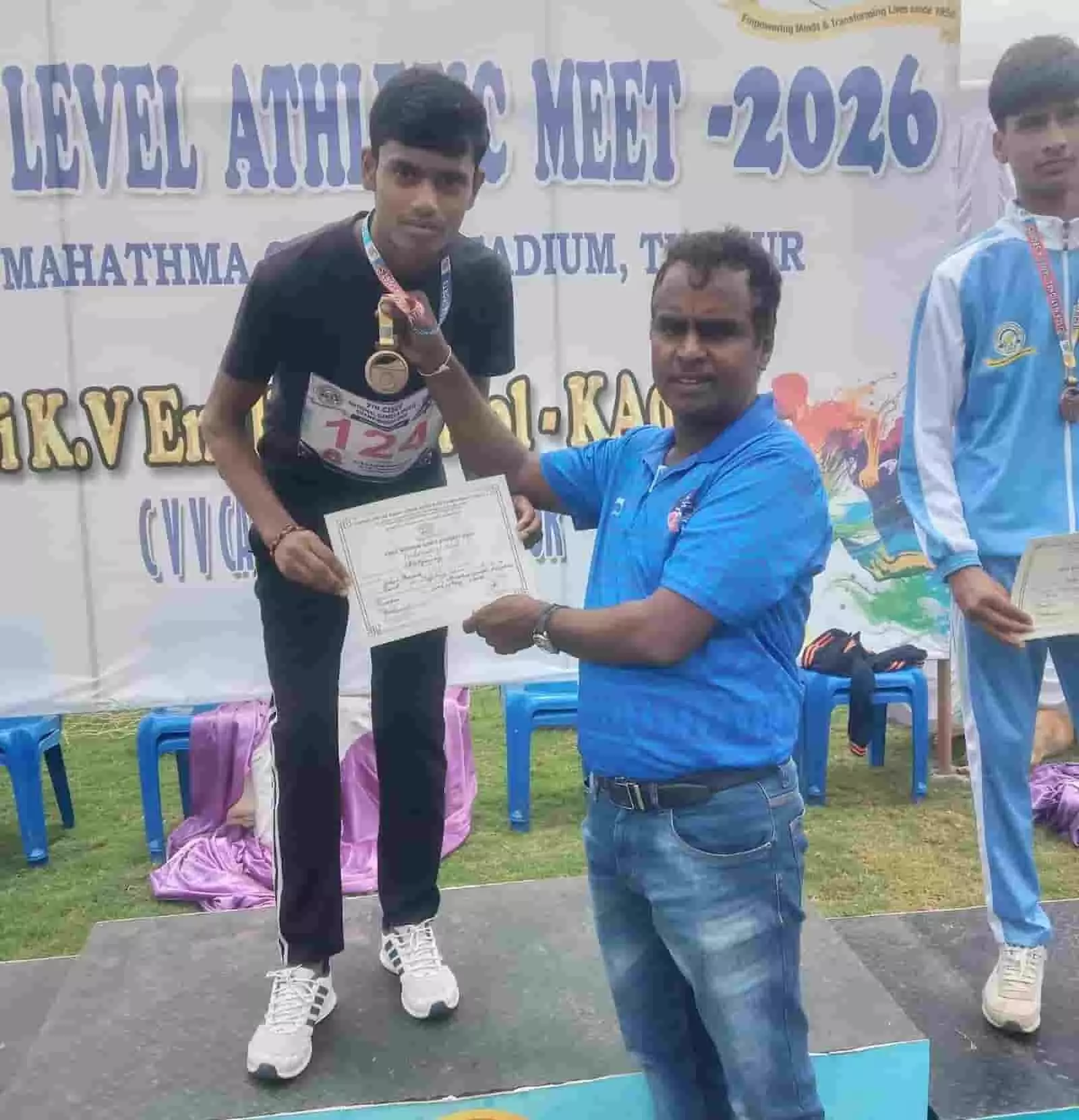तस्वीर में बाईं ओर खड़ा छात्र मेडल पहने हुए व्यक्ति से प्रमाणपत्र ले रहा है। तस्वीर में बाईं ओर खड़ा छात्र मेडल पहने हुए व्यक्ति से प्रमाणपत्र ले रहा है।