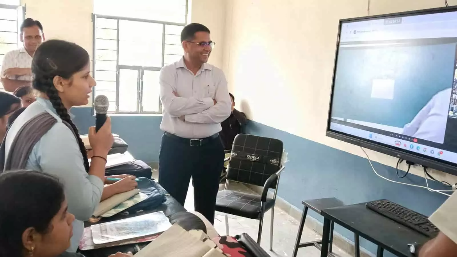 तस्वीर में बाएं से दाएं, हाथ में माइक लिए छात्रा और मुस्कुराते हुए खड़े जिला कलक्टर दिख रहे हैं। तस्वीर में बाएं से दाएं, हाथ में माइक लिए छात्रा और मुस्कुराते हुए खड़े जिला कलक्टर दिख रहे हैं।