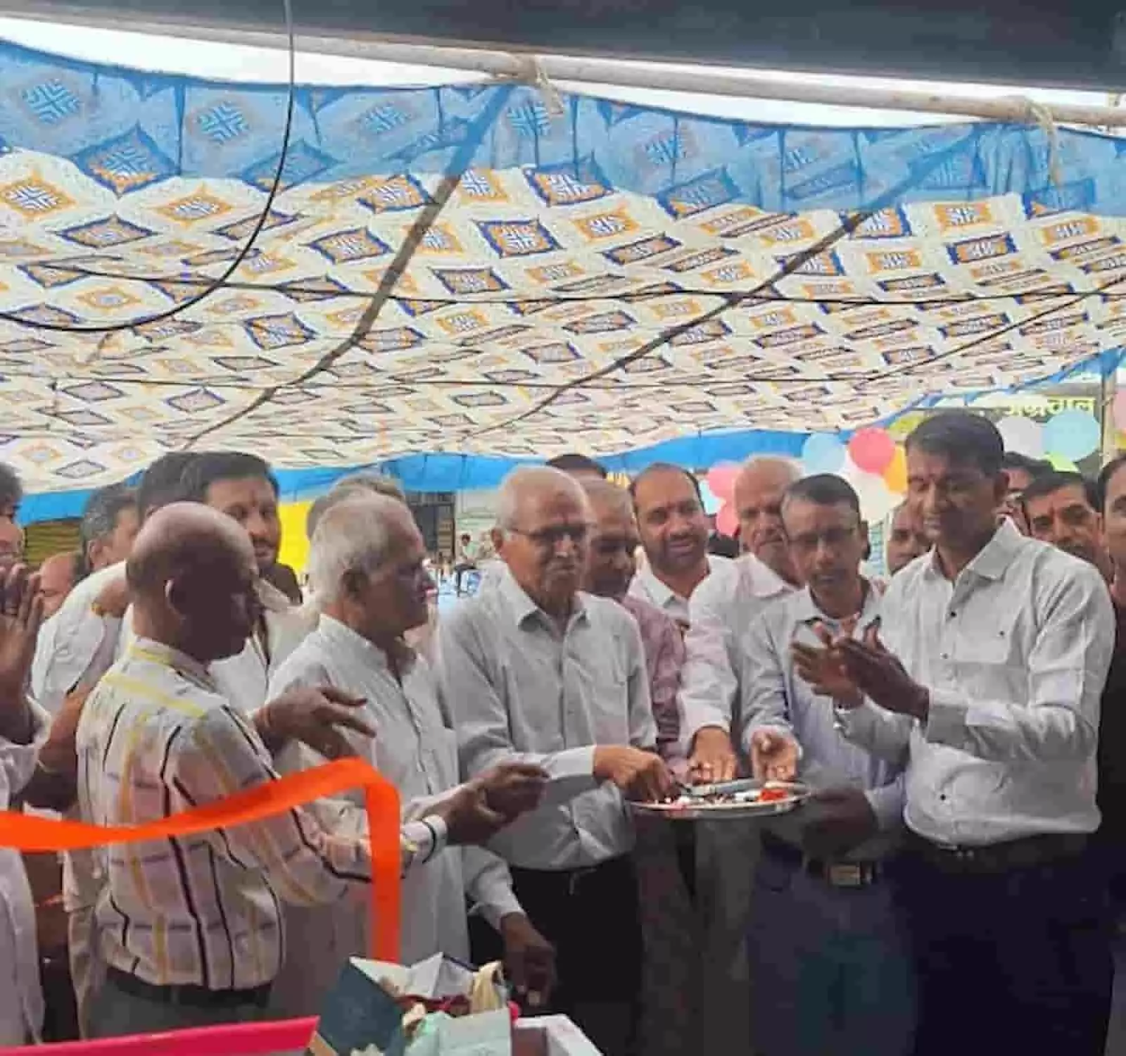 तस्वीर में बाएं से दाएं खड़े लोग पंडाल के नीचे फीता काटकर उद्घाटन समारोह मना रहे हैं। तस्वीर में बाएं से दाएं खड़े लोग पंडाल के नीचे फीता काटकर उद्घाटन समारोह मना रहे हैं।