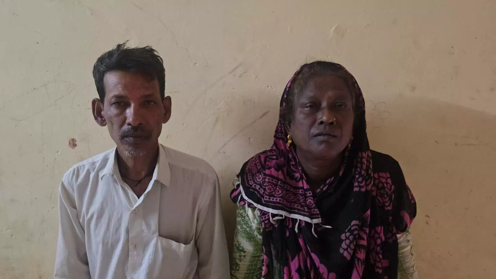 तस्वीर में बाएं ओर एक पुरुष और दाईं ओर एक महिला दीवार के सामने खड़े हैं। तस्वीर में बाएं ओर एक पुरुष और दाईं ओर एक महिला दीवार के सामने खड़े हैं।
