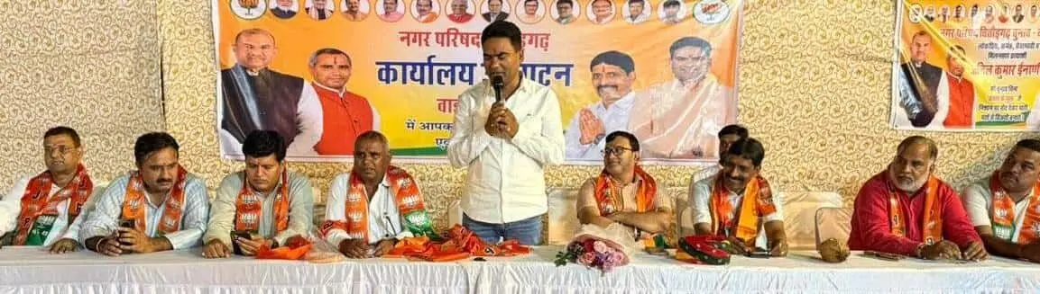 तस्वीर में एक नेता माइक पर भाषण देते हुए और अन्य लोग मंच पर बैठे हैं। तस्वीर में एक नेता माइक पर भाषण देते हुए और अन्य लोग मंच पर बैठे हैं।