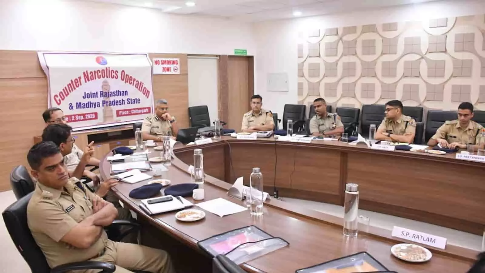 तस्वीर में पुलिस अधिकारी एक बड़े सम्मेलन कक्ष में मेज के चारों ओर बैठकर बैठक करते दिख रहे हैं। तस्वीर में पुलिस अधिकारी एक बड़े सम्मेलन कक्ष में मेज के चारों ओर बैठकर बैठक करते दिख रहे हैं।