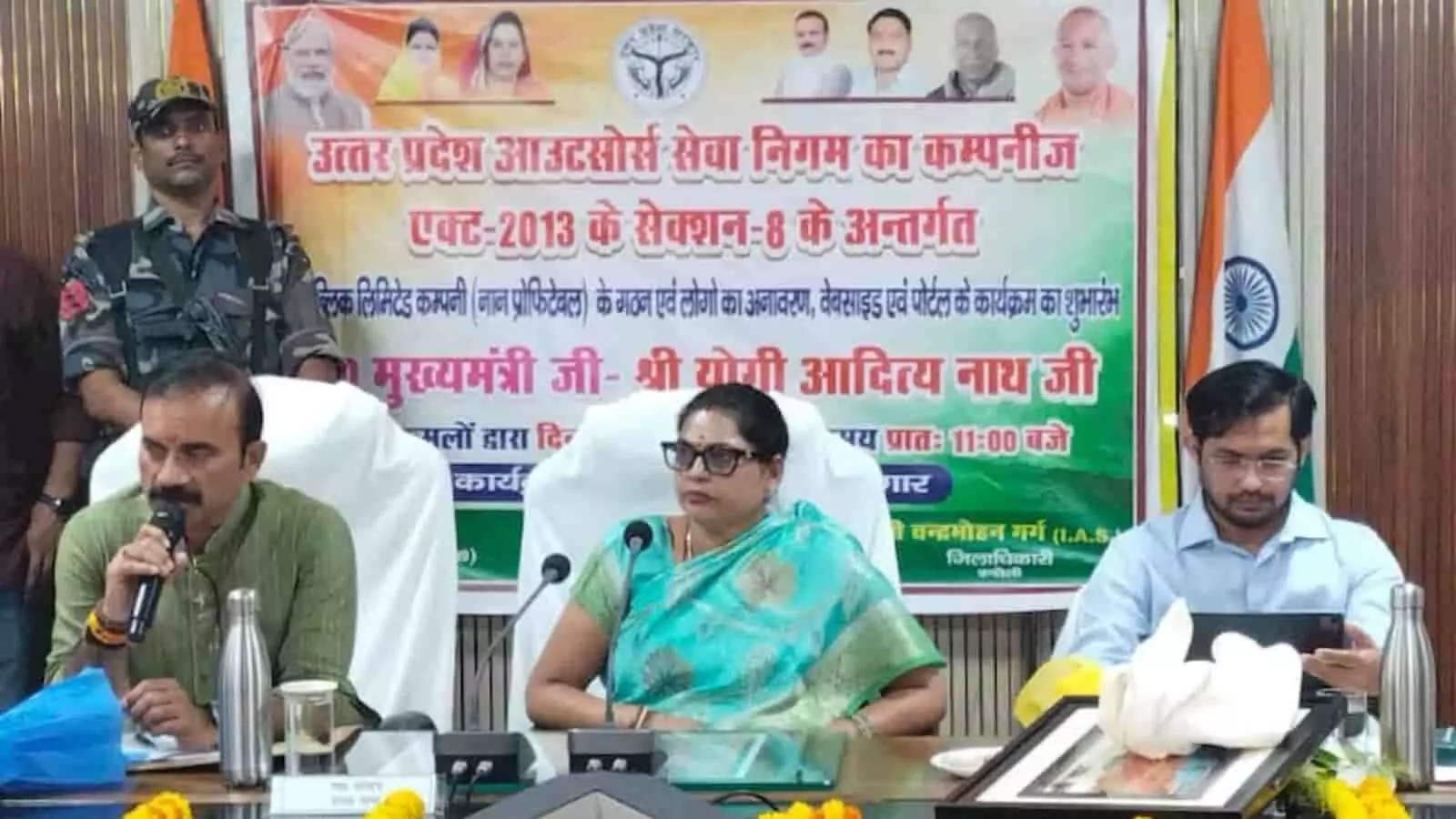 तस्वीर में बाएं से दाएं एक व्यक्ति, साड़ी पहने महिला और एक अन्य अधिकारी मंच पर बैठे दिख रहे हैं। तस्वीर में बाएं से दाएं एक व्यक्ति, साड़ी पहने महिला और एक अन्य अधिकारी मंच पर बैठे दिख रहे हैं।