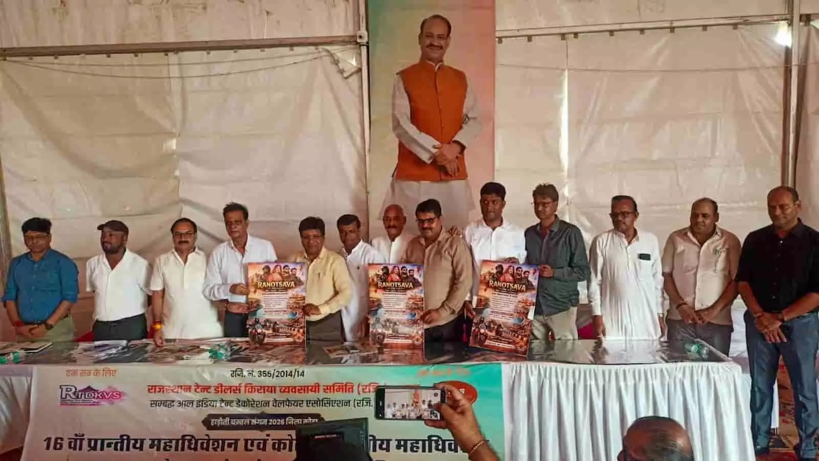 तस्वीर में कई पुरुष कोटा में एक कार्यक्रम के दौरान मंच पर खड़े होकर पोस्टर दिखा रहे हैं। तस्वीर में कई पुरुष कोटा में एक कार्यक्रम के दौरान मंच पर खड़े होकर पोस्टर दिखा रहे हैं।
