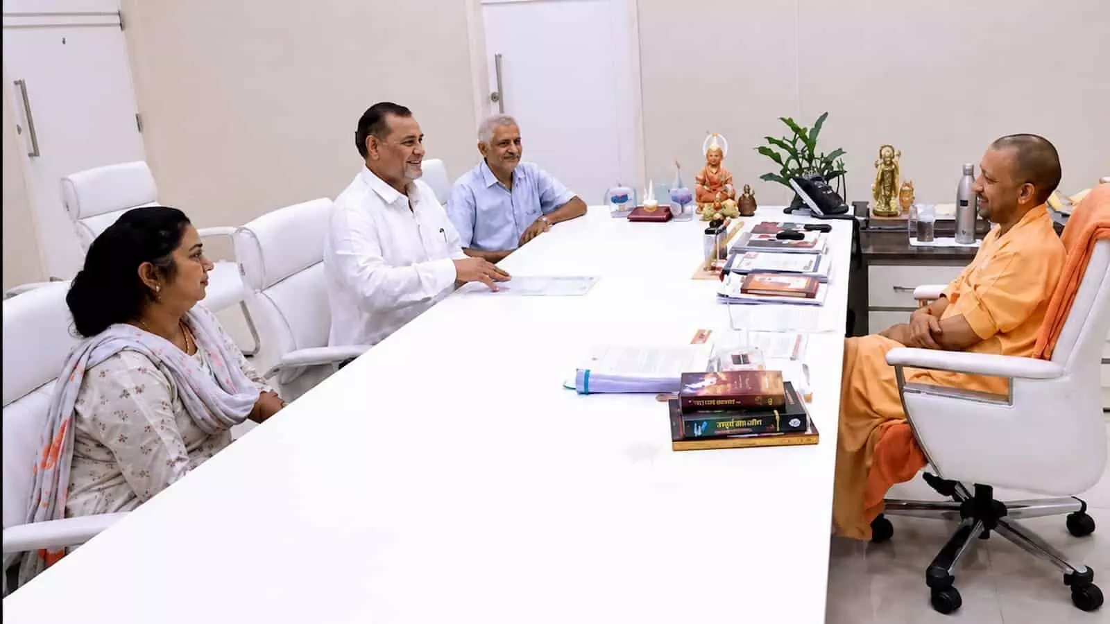 तस्वीर में मुख्यमंत्री योगी आदित्यनाथ एक बड़ी मेज के पास अधिकारियों से बात कर रहे हैं। तस्वीर में मुख्यमंत्री योगी आदित्यनाथ एक बड़ी मेज के पास अधिकारियों से बात कर रहे हैं।
