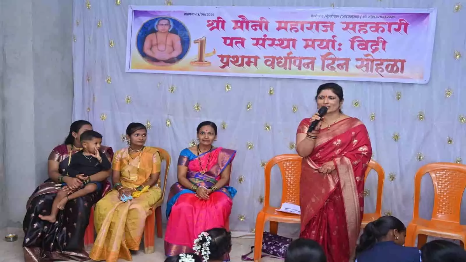 तस्वीर में एक महिला मंच पर माइक से भाषण दे रही हैं और बैठी महिलाएं सुन रही हैं। तस्वीर में एक महिला मंच पर माइक से भाषण दे रही हैं और बैठी महिलाएं सुन रही हैं।