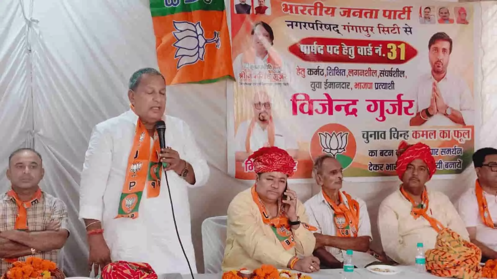 तस्वीर में गंगापुर सिटी के चुनाव कार्यालय में माइक पर भाषण देते भाजपा नेता और बैठे हुए कार्यकर्ता दिखाई दे रहे हैं। तस्वीर में गंगापुर सिटी के चुनाव कार्यालय में माइक पर भाषण देते भाजपा नेता और बैठे हुए कार्यकर्ता दिखाई दे रहे हैं।