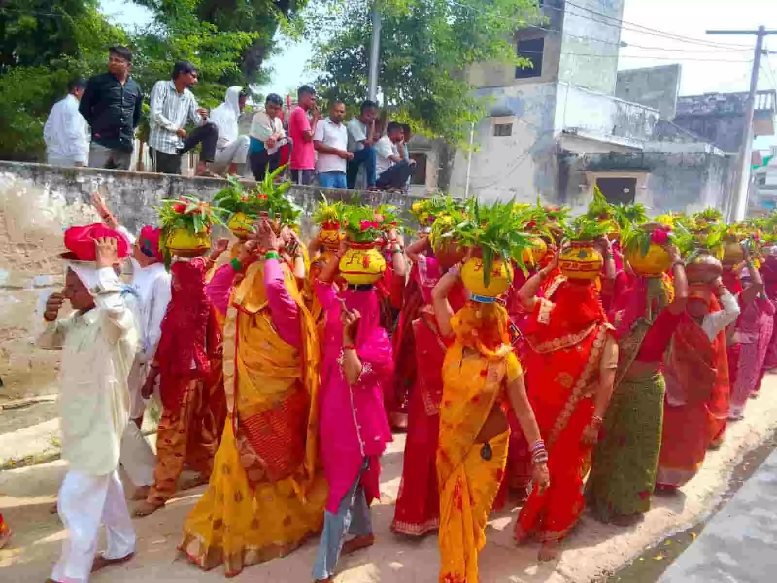 तस्वीर में दिख रही महिलाएं सिर पर मंगल कलश धारण कर गांव की सड़क से पैदल गुजर रही हैं। तस्वीर में दिख रही महिलाएं सिर पर मंगल कलश धारण कर गांव की सड़क से पैदल गुजर रही हैं।