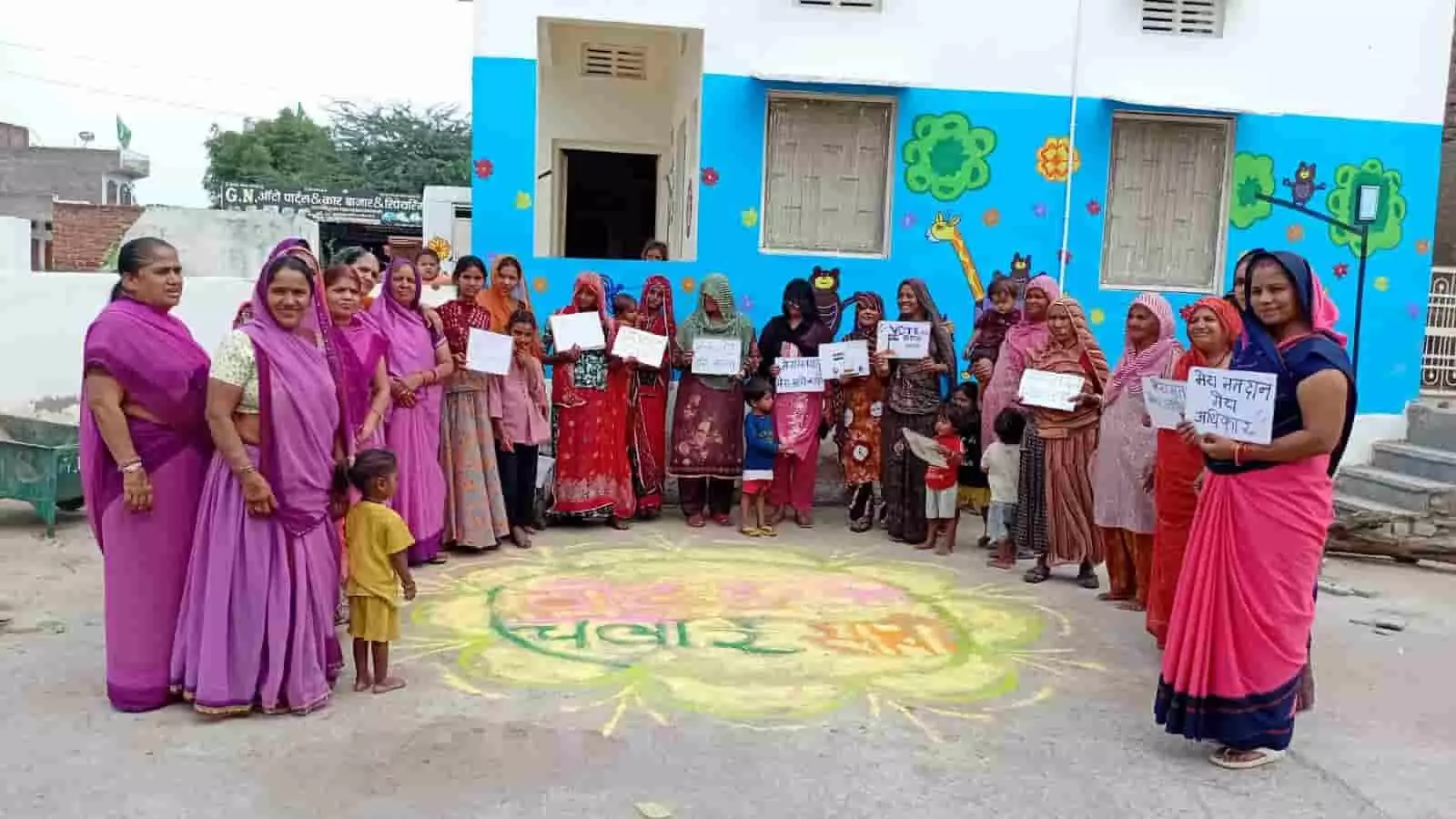तस्वीर में दिख रही आंगनवाड़ी कार्यकर्ता और महिलाएं रंगोली के पास हाथ में पोस्टर लेकर खड़ी हैं। तस्वीर में दिख रही आंगनवाड़ी कार्यकर्ता और महिलाएं रंगोली के पास हाथ में पोस्टर लेकर खड़ी हैं।