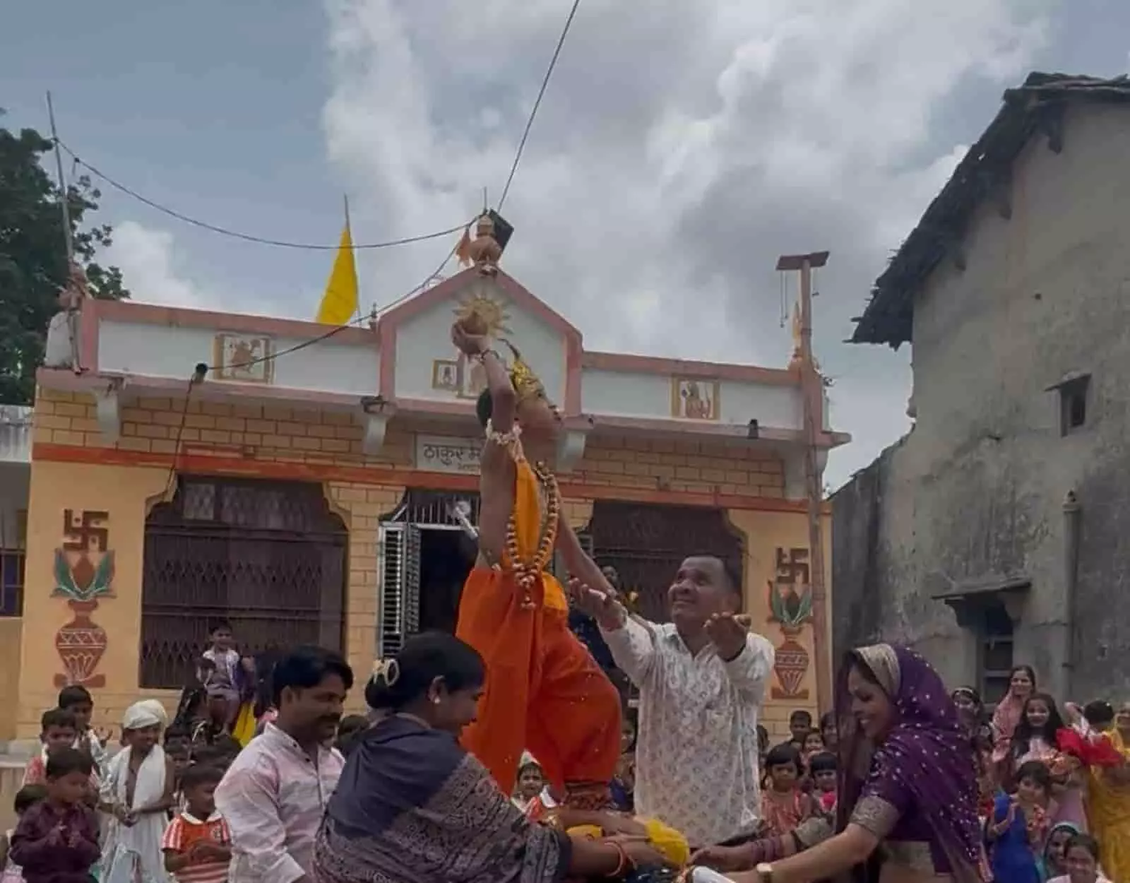 तस्वीर में दिख रही कृष्ण रूपी पोशाक पहने बच्चे को लोग मटकी फोड़ने के लिए सहारा दे रहे हैं। तस्वीर में दिख रही कृष्ण रूपी पोशाक पहने बच्चे को लोग मटकी फोड़ने के लिए सहारा दे रहे हैं।