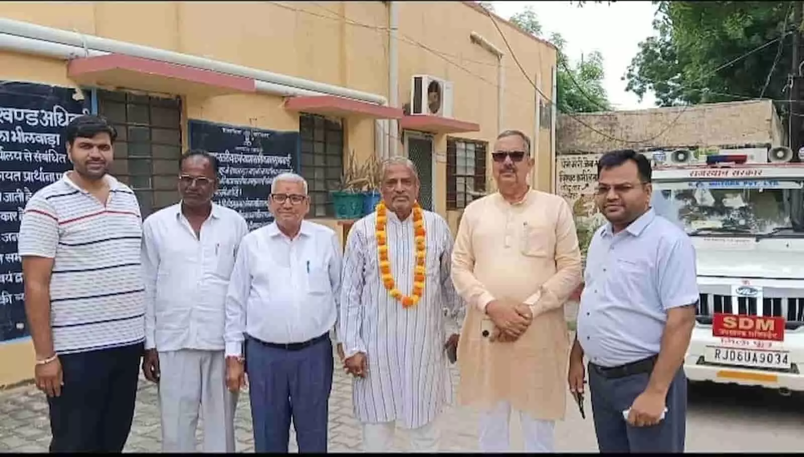 तस्वीर में दिख रहे छह पुरुष गंगापुर उपखंड कार्यालय के बाहर कतार में खड़े हैं। तस्वीर में दिख रहे छह पुरुष गंगापुर उपखंड कार्यालय के बाहर कतार में खड़े हैं।