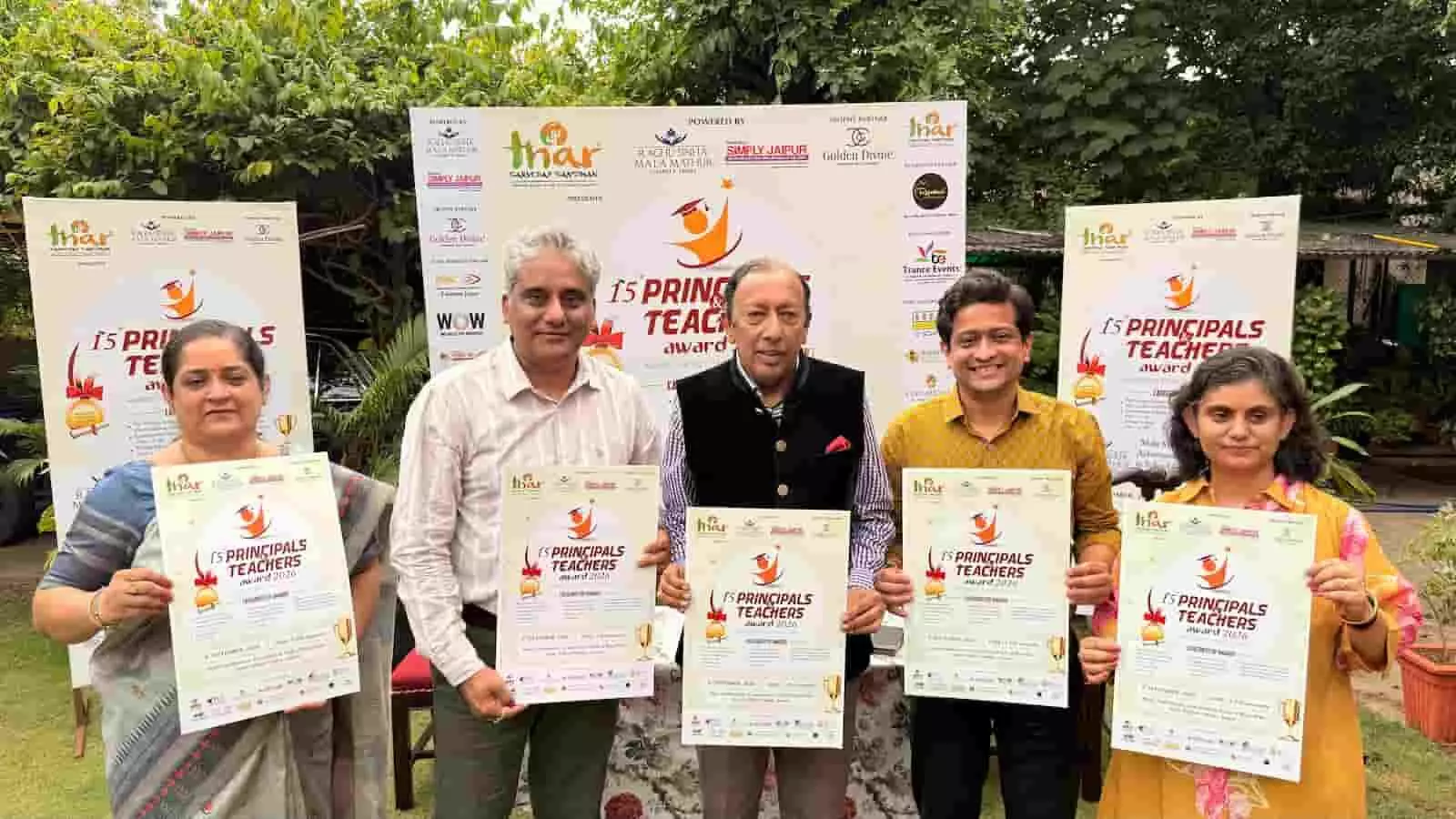 तस्वीर में दो महिलाएं और तीन पुरुष हाथ में कार्यक्रम के पोस्टर लिए बगीचे में खड़े हैं। तस्वीर में दो महिलाएं और तीन पुरुष हाथ में कार्यक्रम के पोस्टर लिए बगीचे में खड़े हैं।