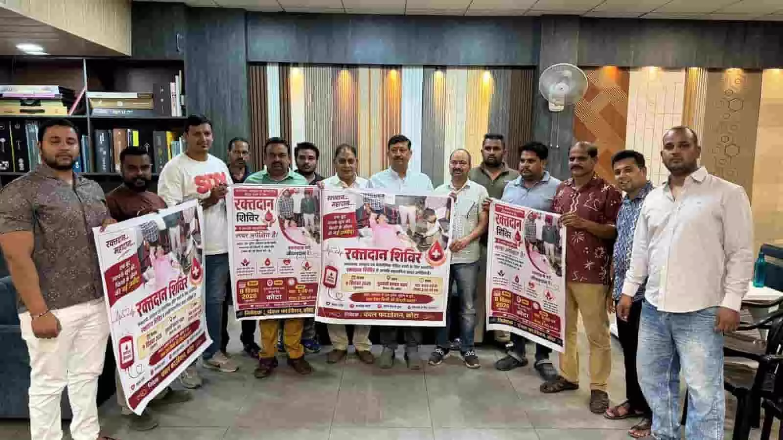 तस्वीर में दिख रही एक इनडोर जगह पर कई लोग हाथ में रक्तदान शिविर के पोस्टर पकड़े हुए हैं। तस्वीर में दिख रही एक इनडोर जगह पर कई लोग हाथ में रक्तदान शिविर के पोस्टर पकड़े हुए हैं।