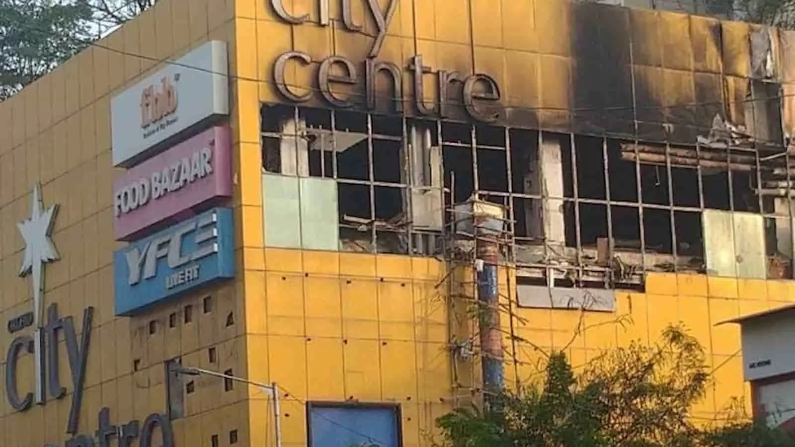 तस्वीर में आग से जली पीली इमारत और टूटी हुई खिड़कियां नजर आ रही हैं। तस्वीर में आग से जली पीली इमारत और टूटी हुई खिड़कियां नजर आ रही हैं।
