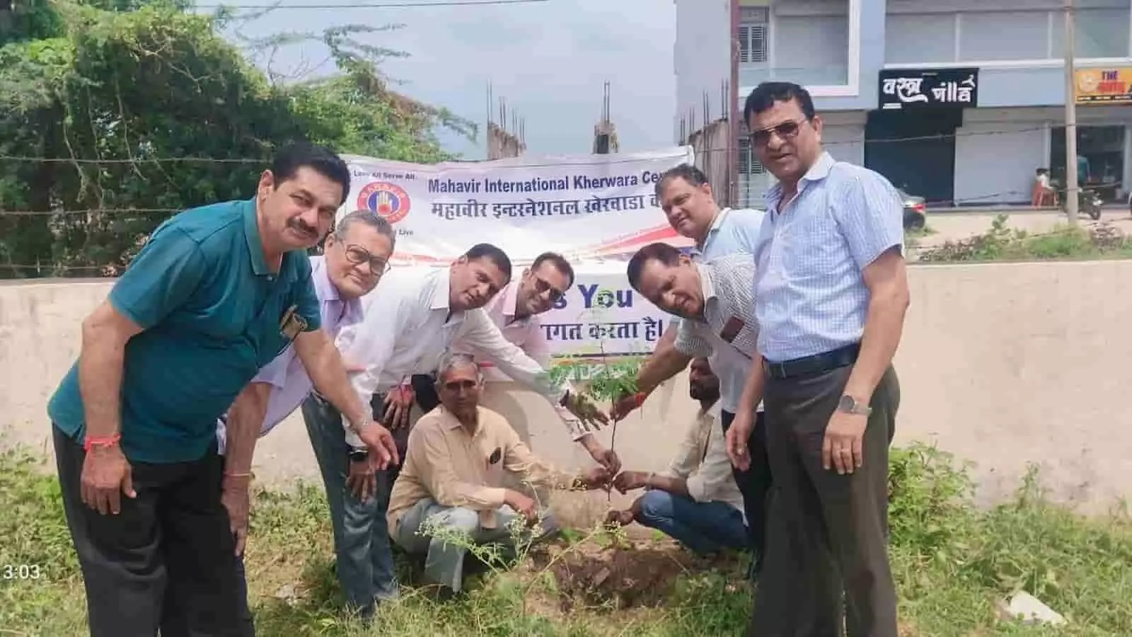 तस्वीर में बाईं से दाईं ओर खड़े पुरुष ज़मीन पर एक छोटा पौधा रोप रहे हैं। तस्वीर में बाईं से दाईं ओर खड़े पुरुष ज़मीन पर एक छोटा पौधा रोप रहे हैं।