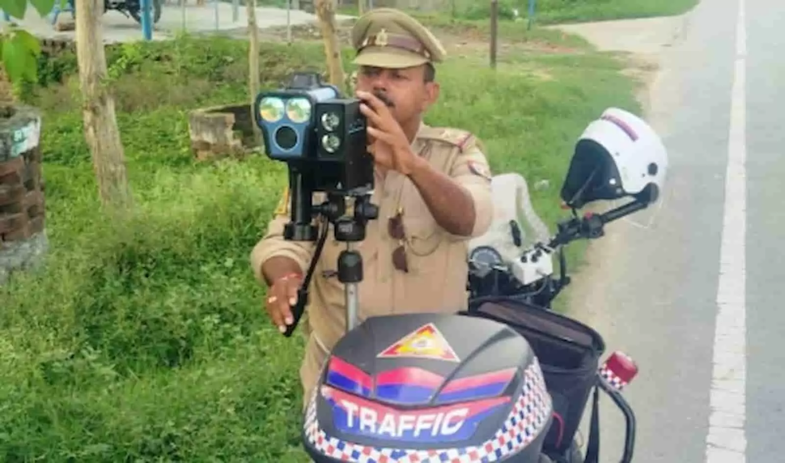 तस्वीर में सड़क किनारे खड़े दोपहिया इंटरसेप्टर वाहन के साथ पुलिसकर्मी आधुनिक उपकरण का उपयोग कर रहा है। तस्वीर में सड़क किनारे खड़े दोपहिया इंटरसेप्टर वाहन के साथ पुलिसकर्मी आधुनिक उपकरण का उपयोग कर रहा है।
