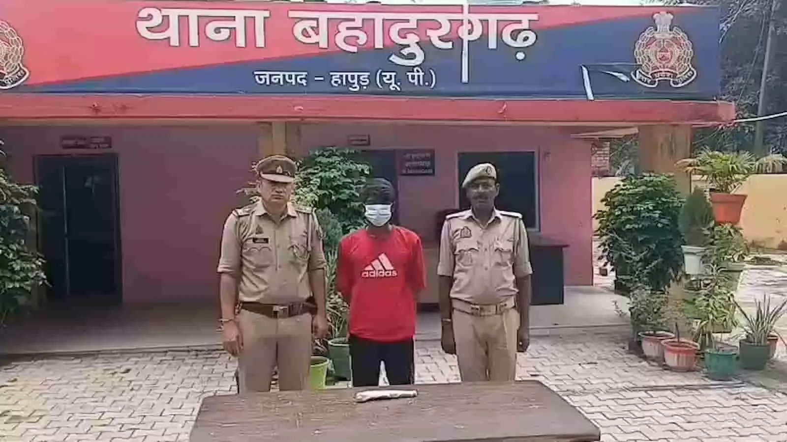 थाना बहादुरगढ़ के बाहर पुलिस हिरासत में खड़ा संदिग्ध आरोपी और दो पुलिसकर्मी। थाना बहादुरगढ़ के बाहर पुलिस हिरासत में खड़ा संदिग्ध आरोपी और दो पुलिसकर्मी।