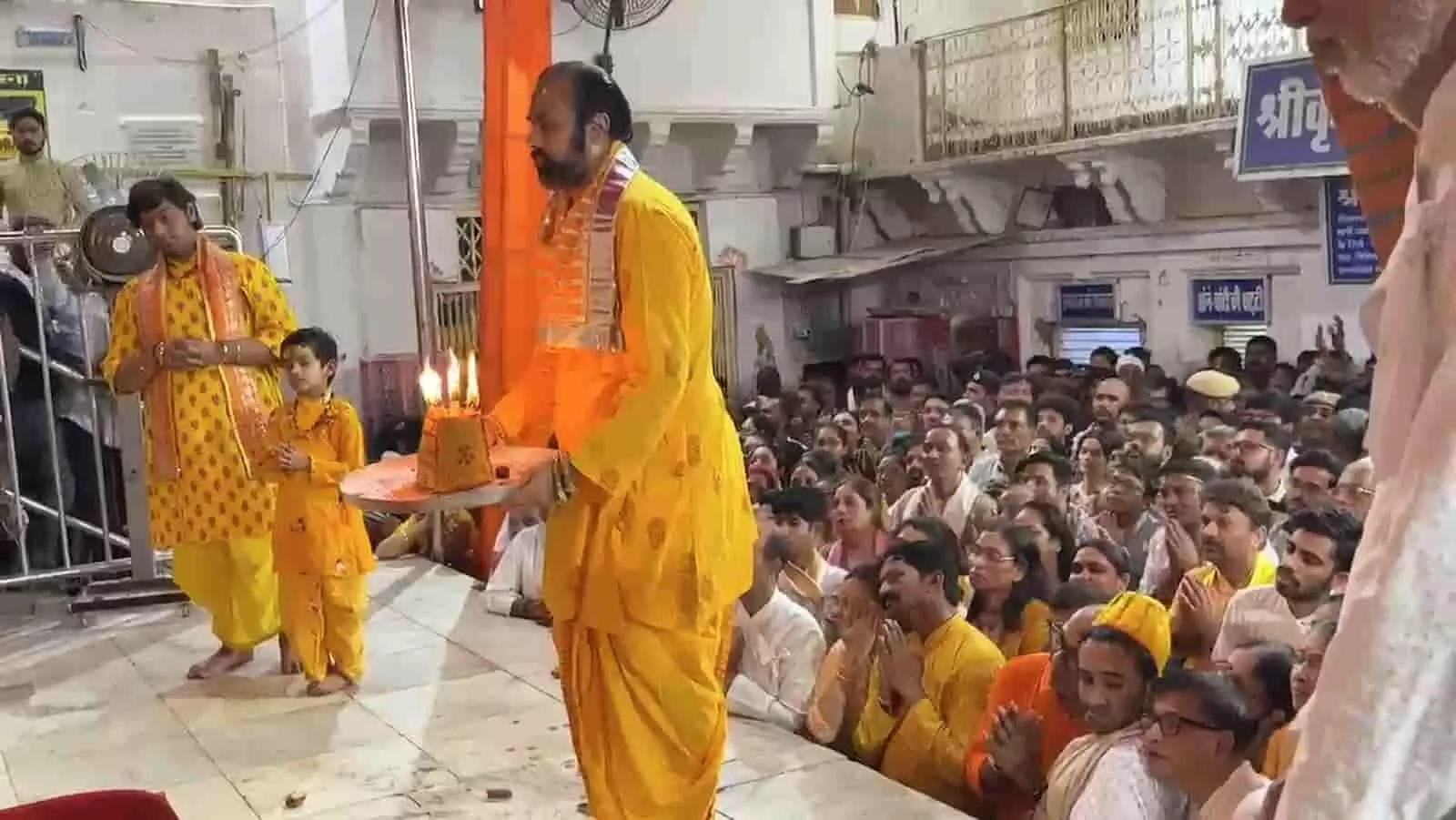 तस्वीर में पीले वस्त्र पहने पुजारी हाथ में दीपक लेकर आरती करते दिख रहे हैं। तस्वीर में पीले वस्त्र पहने पुजारी हाथ में दीपक लेकर आरती करते दिख रहे हैं।
