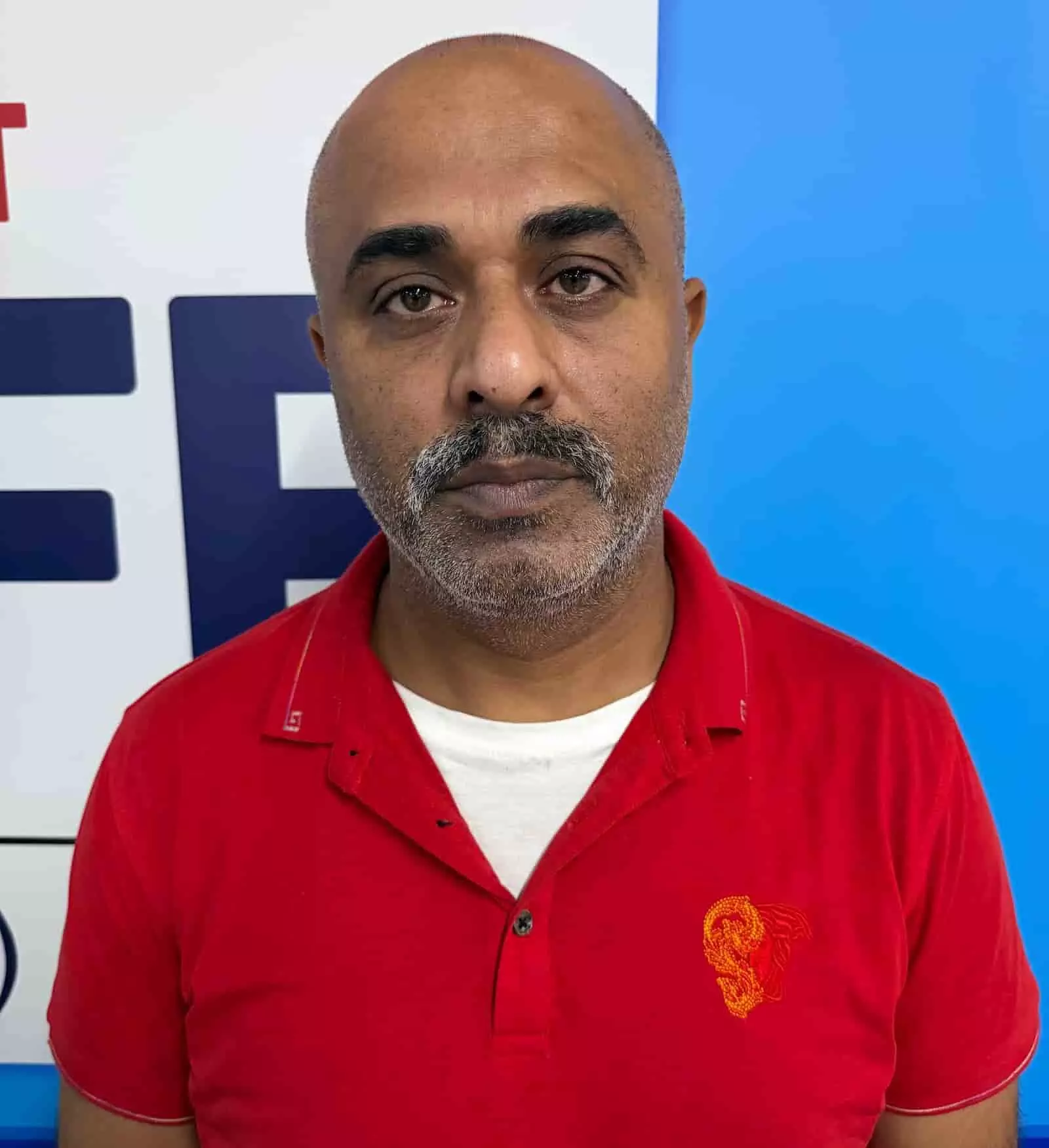 तस्वीर में लाल टी-शर्ट पहने आरोपी करण आसवानी पुलिस हिरासत के दौरान सामने देखता हुआ। तस्वीर में लाल टी-शर्ट पहने आरोपी करण आसवानी पुलिस हिरासत के दौरान सामने देखता हुआ।