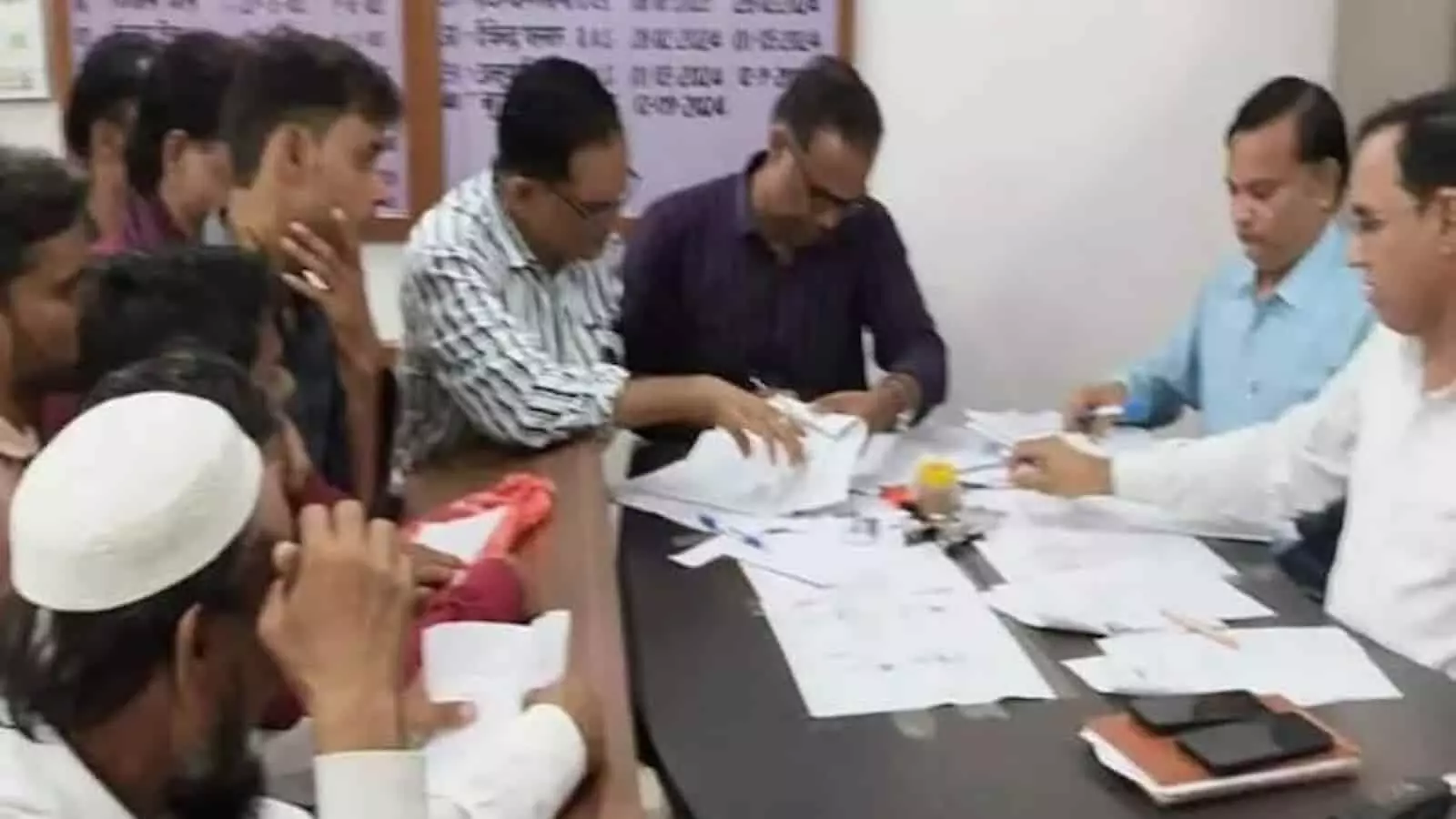 तस्वीर में गंगापुर सिटी नगर परिषद चुनाव के तहत दस्तावेज जांचते अधिकारी और लोग दिख रहे हैं। तस्वीर में गंगापुर सिटी नगर परिषद चुनाव के तहत दस्तावेज जांचते अधिकारी और लोग दिख रहे हैं।