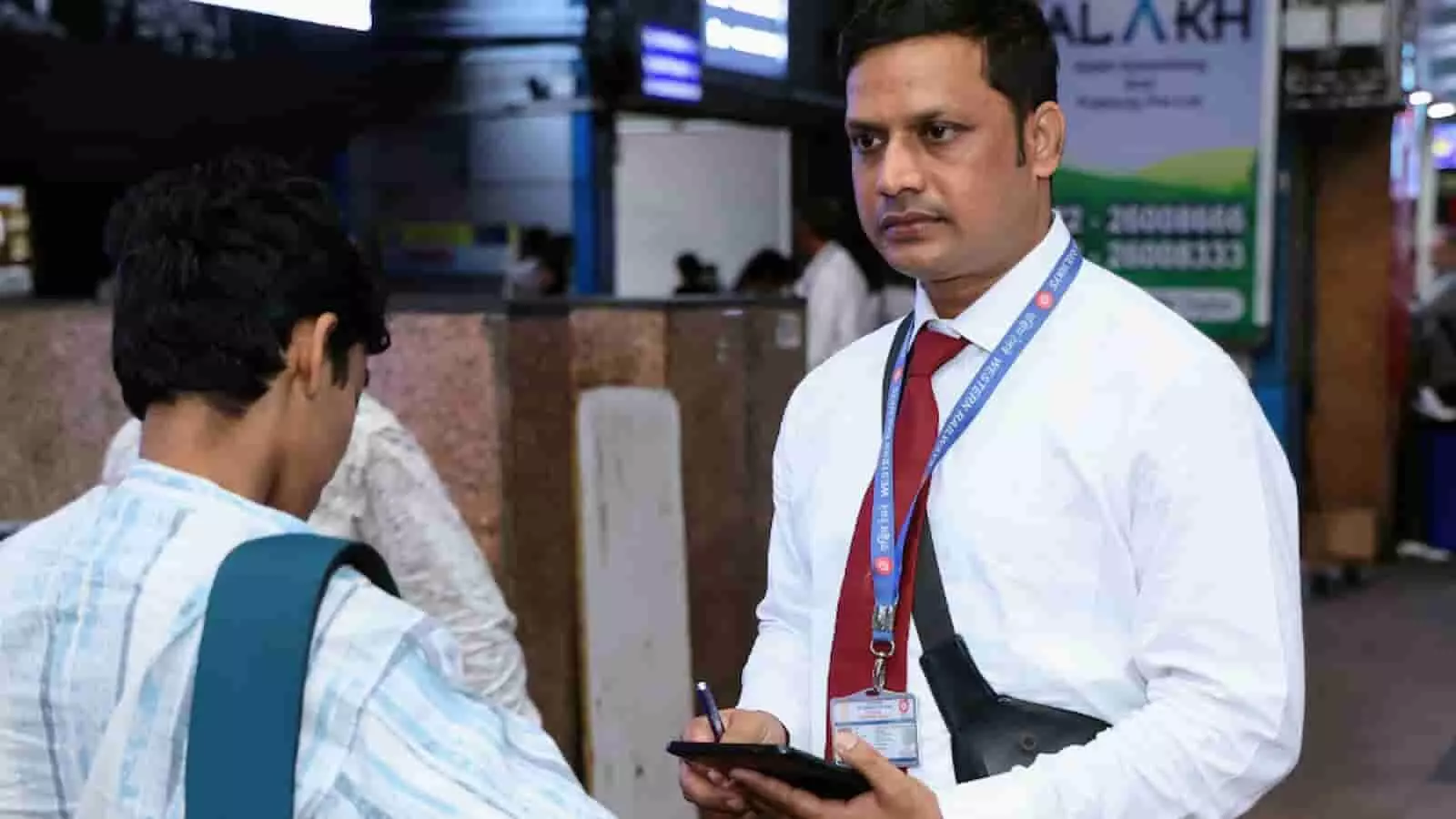 रेलवे स्टेशन पर टिकट चेकिंग कर्मचारी यात्री के दस्तावेजों की जांच कर रहा है। रेलवे स्टेशन पर टिकट चेकिंग कर्मचारी यात्री के दस्तावेजों की जांच कर रहा है।