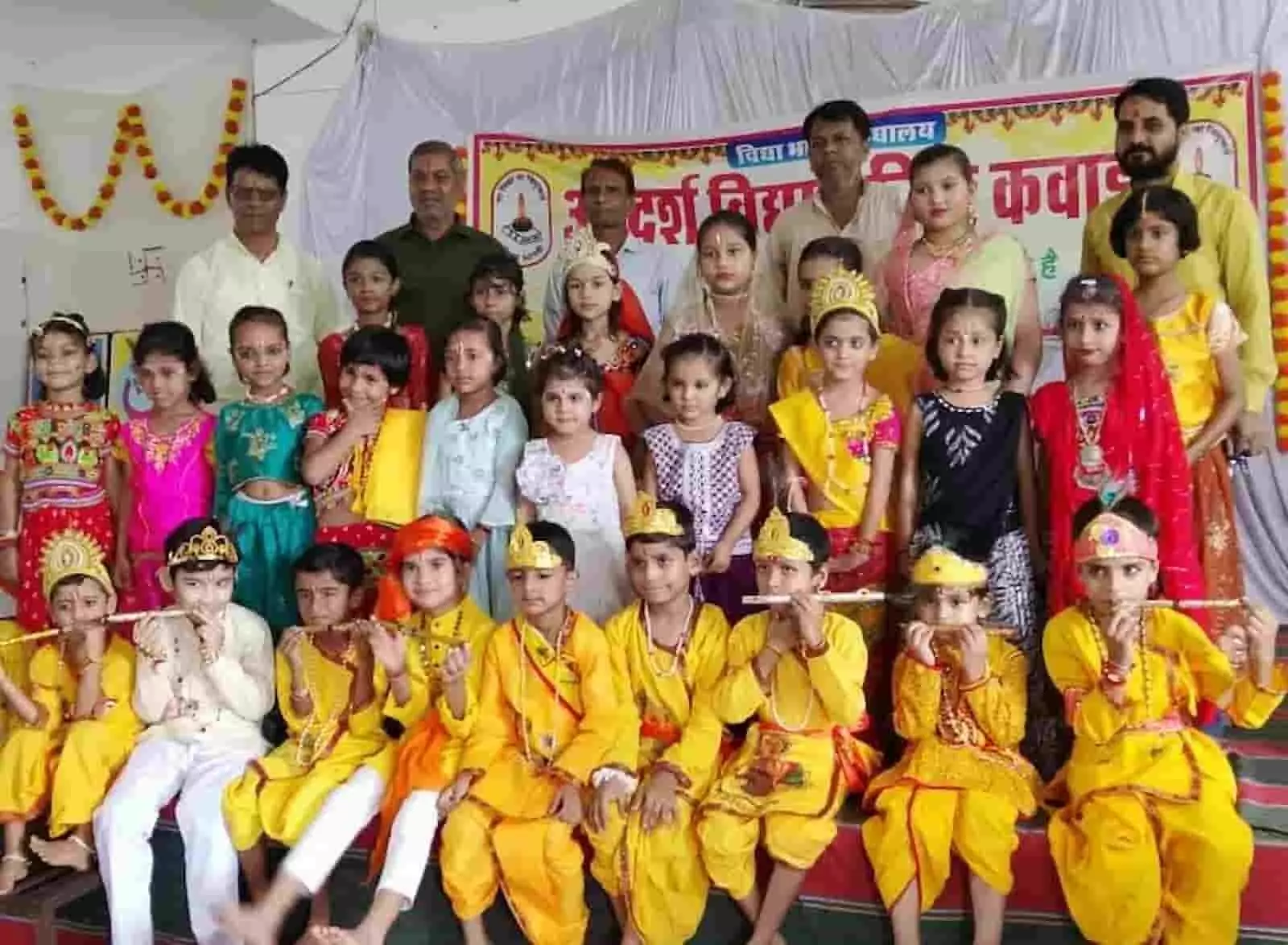 तस्वीर में दिख रही पोशाक पहने नन्हे बच्चे और पीछे खड़े शिक्षक मंच पर प्रस्तुत हैं। तस्वीर में दिख रही पोशाक पहने नन्हे बच्चे और पीछे खड़े शिक्षक मंच पर प्रस्तुत हैं।