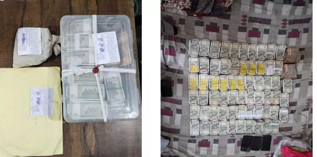 तस्वीर में भारी मात्रा में बरामद नकदी के बंडल और तीन मोबाइल फोन एक बिस्तर पर सजे हुए हैं। तस्वीर में भारी मात्रा में बरामद नकदी के बंडल और तीन मोबाइल फोन एक बिस्तर पर सजे हुए हैं।