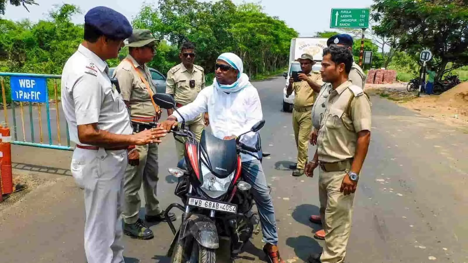 तस्वीर में पुलिसकर्मी राजमार्ग पर एक बाइक सवार को रोककर ट्रैफिक जांच कर रहे हैं। तस्वीर में पुलिसकर्मी राजमार्ग पर एक बाइक सवार को रोककर ट्रैफिक जांच कर रहे हैं।