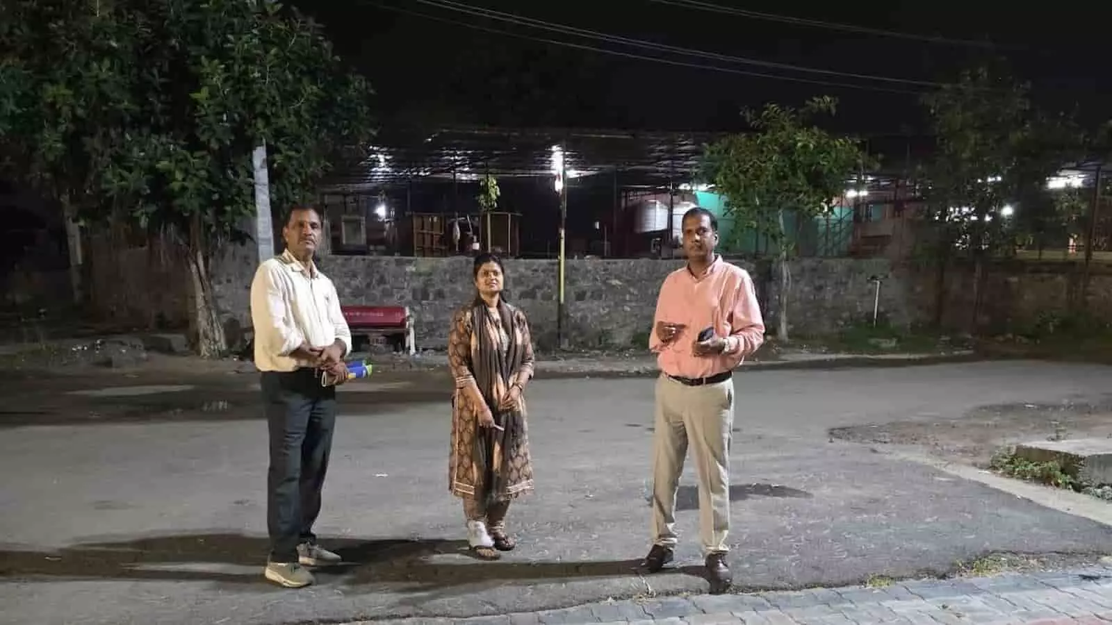 तस्वीर में बाएँ से दाएँ दो पुरुष और एक महिला अधिकारी रात में सड़क पर खड़े हैं। तस्वीर में बाएँ से दाएँ दो पुरुष और एक महिला अधिकारी रात में सड़क पर खड़े हैं।