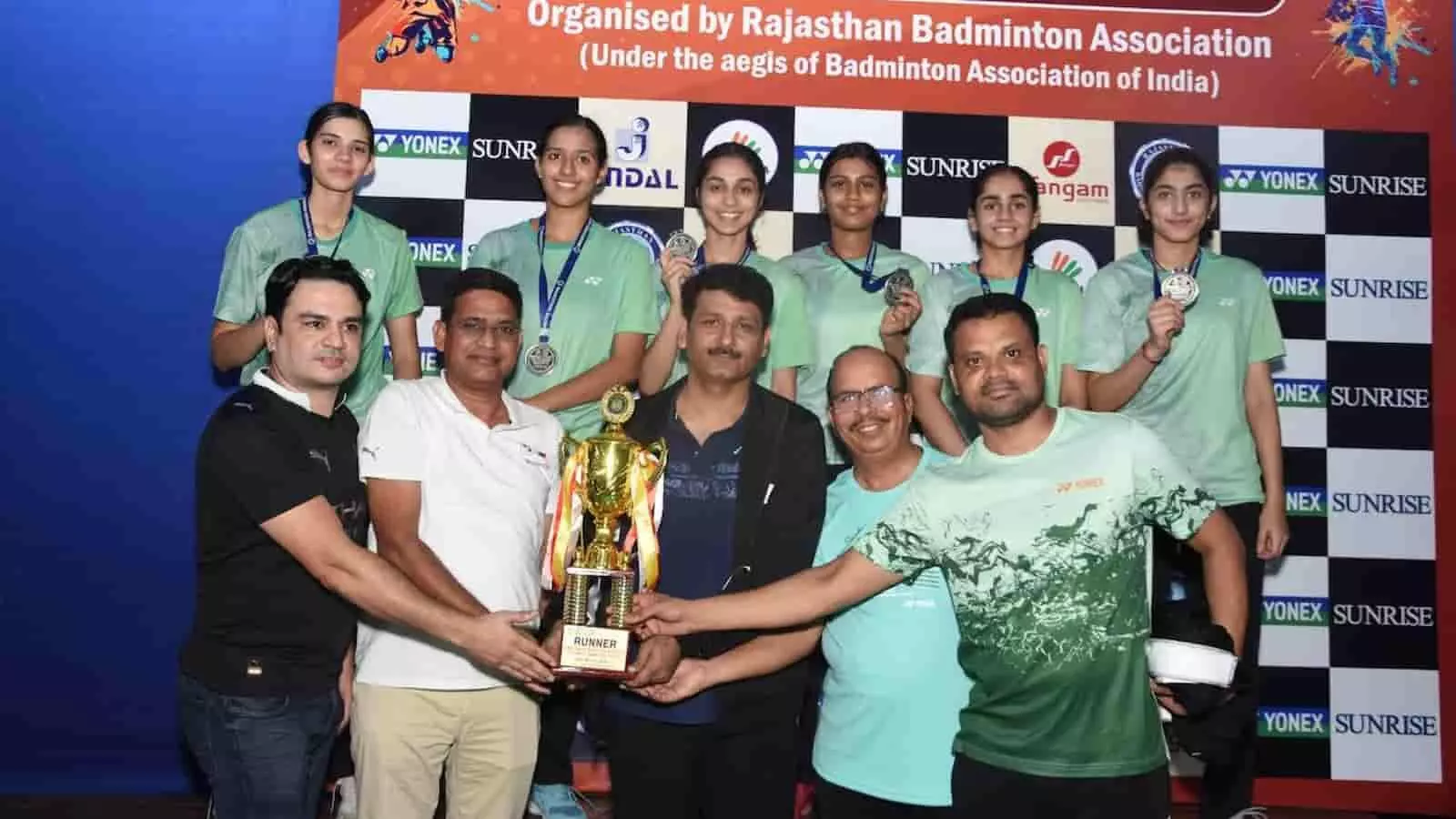 तस्वीर में मंच पर अतिथि रनर-अप ट्रॉफी थामे खड़े हैं और पीछे महिला खिलाड़ी मेडल पहनकर मुस्कुरा रही हैं। तस्वीर में मंच पर अतिथि रनर-अप ट्रॉफी थामे खड़े हैं और पीछे महिला खिलाड़ी मेडल पहनकर मुस्कुरा रही हैं।