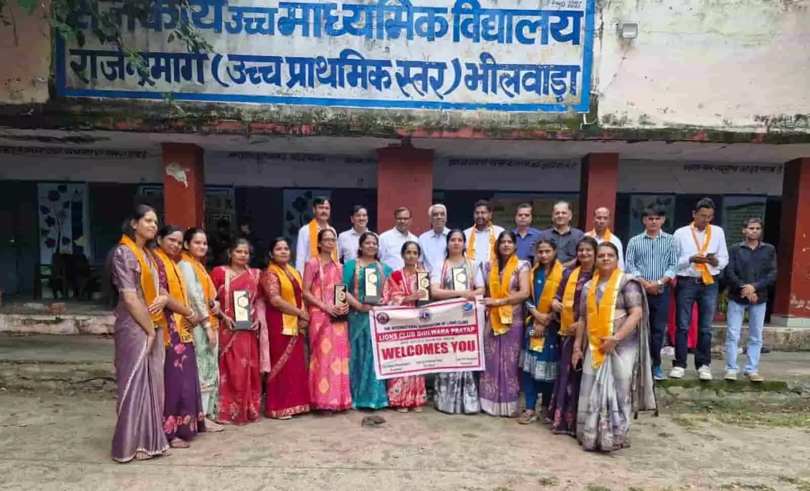 तस्वीर में भीलवाड़ा के स्कूल परिसर में हाथ में ट्रॉफी और बैनर लिए शिक्षक खड़े हैं। तस्वीर में भीलवाड़ा के स्कूल परिसर में हाथ में ट्रॉफी और बैनर लिए शिक्षक खड़े हैं।