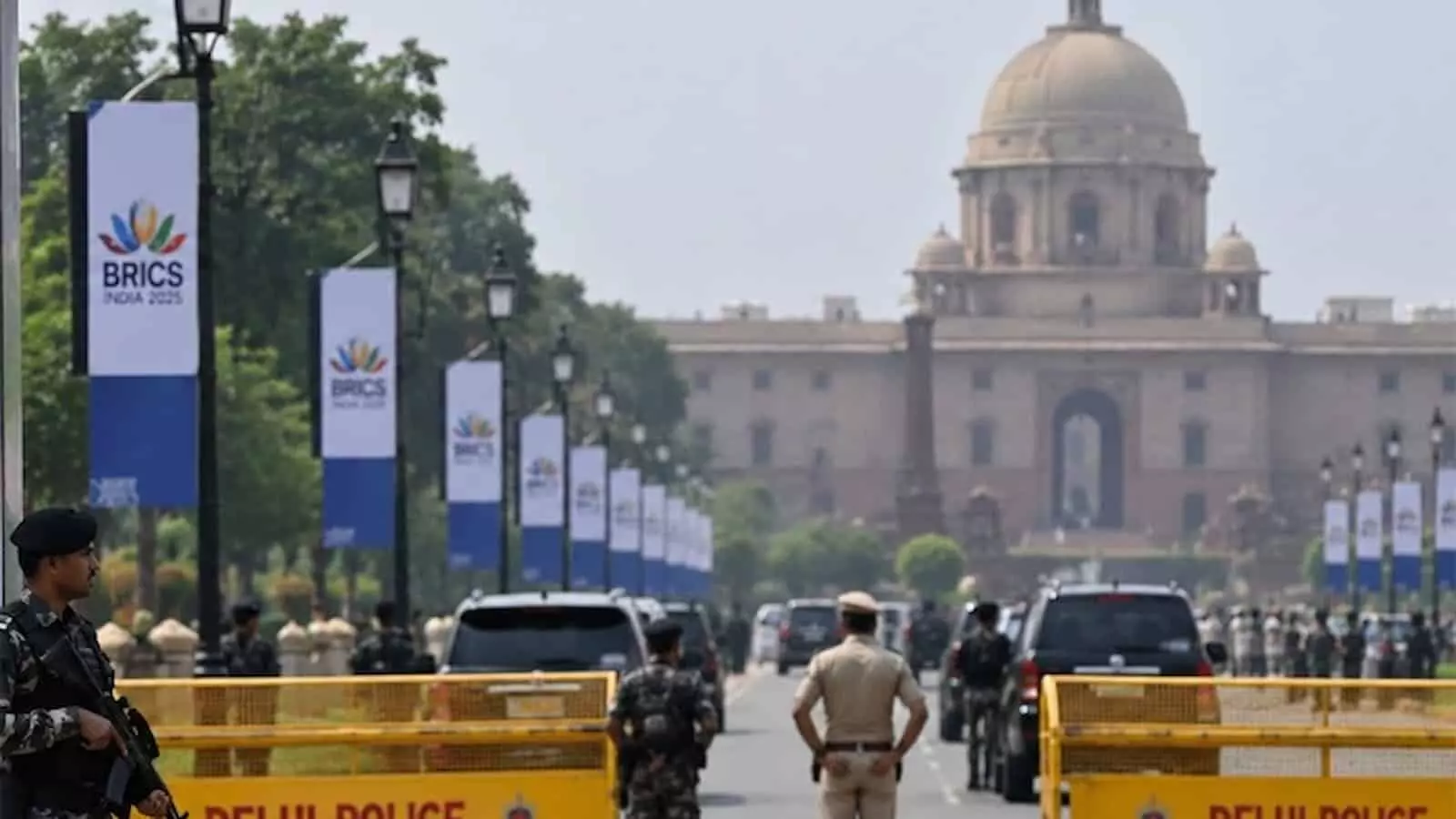 तस्वीर में दिल्ली पुलिस के जवान सड़क पर लगे बैरिकेड्स और ब्रिक्स पोस्टरों के पास तैनात दिखाई दे रहे हैं। तस्वीर में दिल्ली पुलिस के जवान सड़क पर लगे बैरिकेड्स और ब्रिक्स पोस्टरों के पास तैनात दिखाई दे रहे हैं।