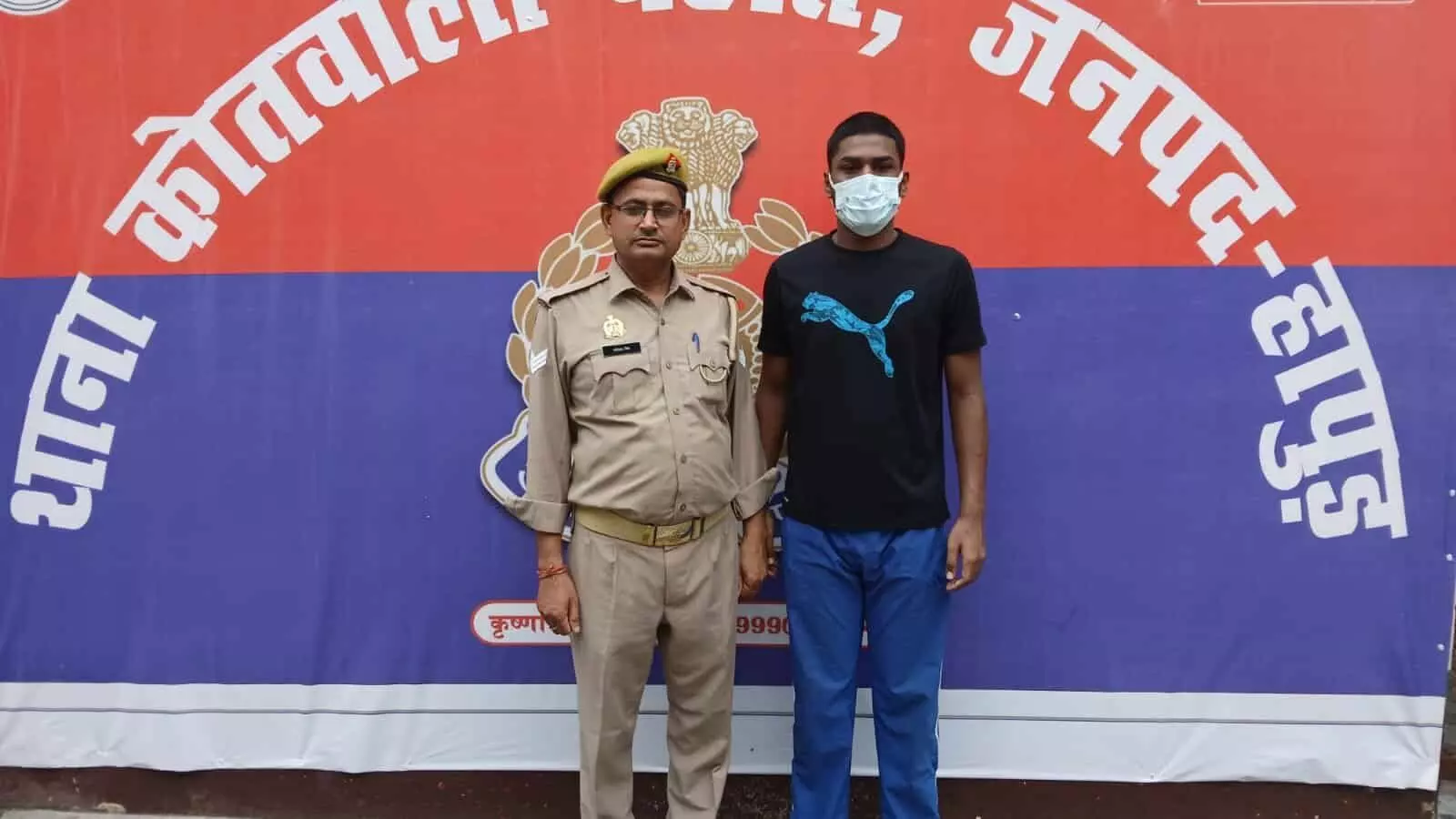 हापुड़ थाने के बोर्ड के आगे बाएं पुलिस अधिकारी और दाएं मास्क पहने आरोपी खड़ा है। हापुड़ थाने के बोर्ड के आगे बाएं पुलिस अधिकारी और दाएं मास्क पहने आरोपी खड़ा है।