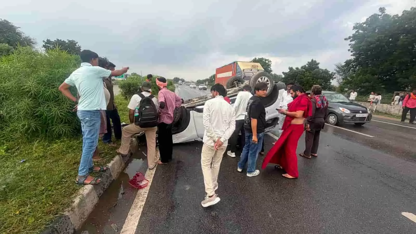 चित्तौड़गढ़ हाईवे पर पलटी सफेद कार के पास बाएं से दाएं ओर राहगीर और स्थानीय लोग खड़े हैं। चित्तौड़गढ़ हाईवे पर पलटी सफेद कार के पास बाएं से दाएं ओर राहगीर और स्थानीय लोग खड़े हैं।