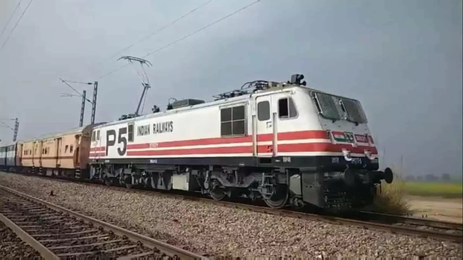तस्वीर में रेलवे ट्रैक पर खड़ी भारतीय रेलवे की पैसेंजर ट्रेन दिख रही है। तस्वीर में रेलवे ट्रैक पर खड़ी भारतीय रेलवे की पैसेंजर ट्रेन दिख रही है।