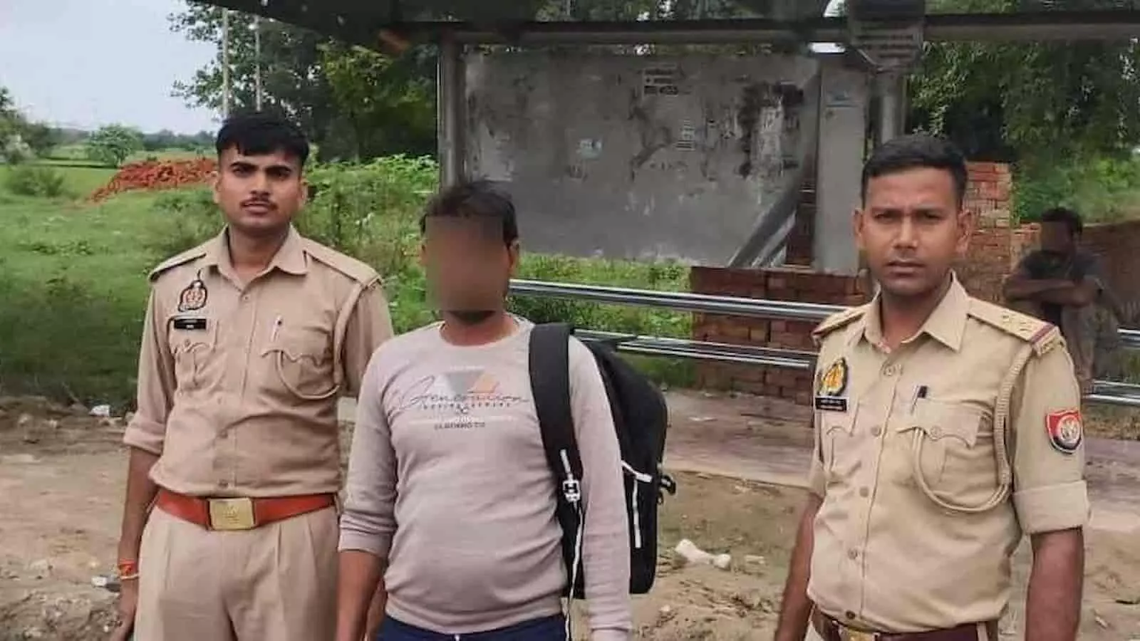 तस्वीर में बाएं पुलिसकर्मी, बीच में बैग लटकाए व्यक्ति और दाएं अन्य पुलिसकर्मी बाहर खड़े हैं। तस्वीर में बाएं पुलिसकर्मी, बीच में बैग लटकाए व्यक्ति और दाएं अन्य पुलिसकर्मी बाहर खड़े हैं।