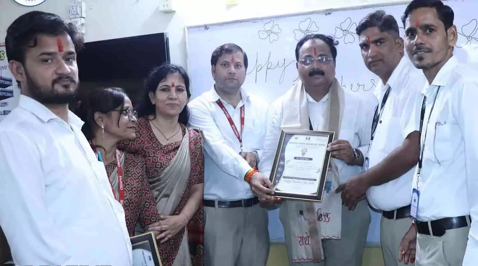तस्वीर में दिख रही अध्यापिकाओं और अध्यापकों के समूह को सम्मानित किया जा रहा है। तस्वीर में दिख रही अध्यापिकाओं और अध्यापकों के समूह को सम्मानित किया जा रहा है।