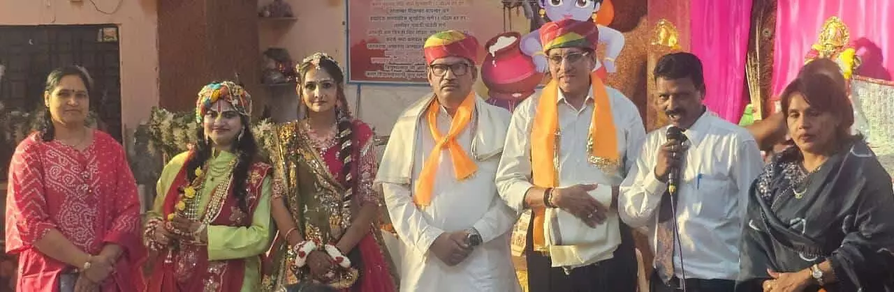तस्वीर में बाएं सजे हुए कलाकार, बीच में साफा पहने पुरुष और दाएं माइक पकड़े व्यक्ति खड़े हैं। तस्वीर में बाएं सजे हुए कलाकार, बीच में साफा पहने पुरुष और दाएं माइक पकड़े व्यक्ति खड़े हैं।