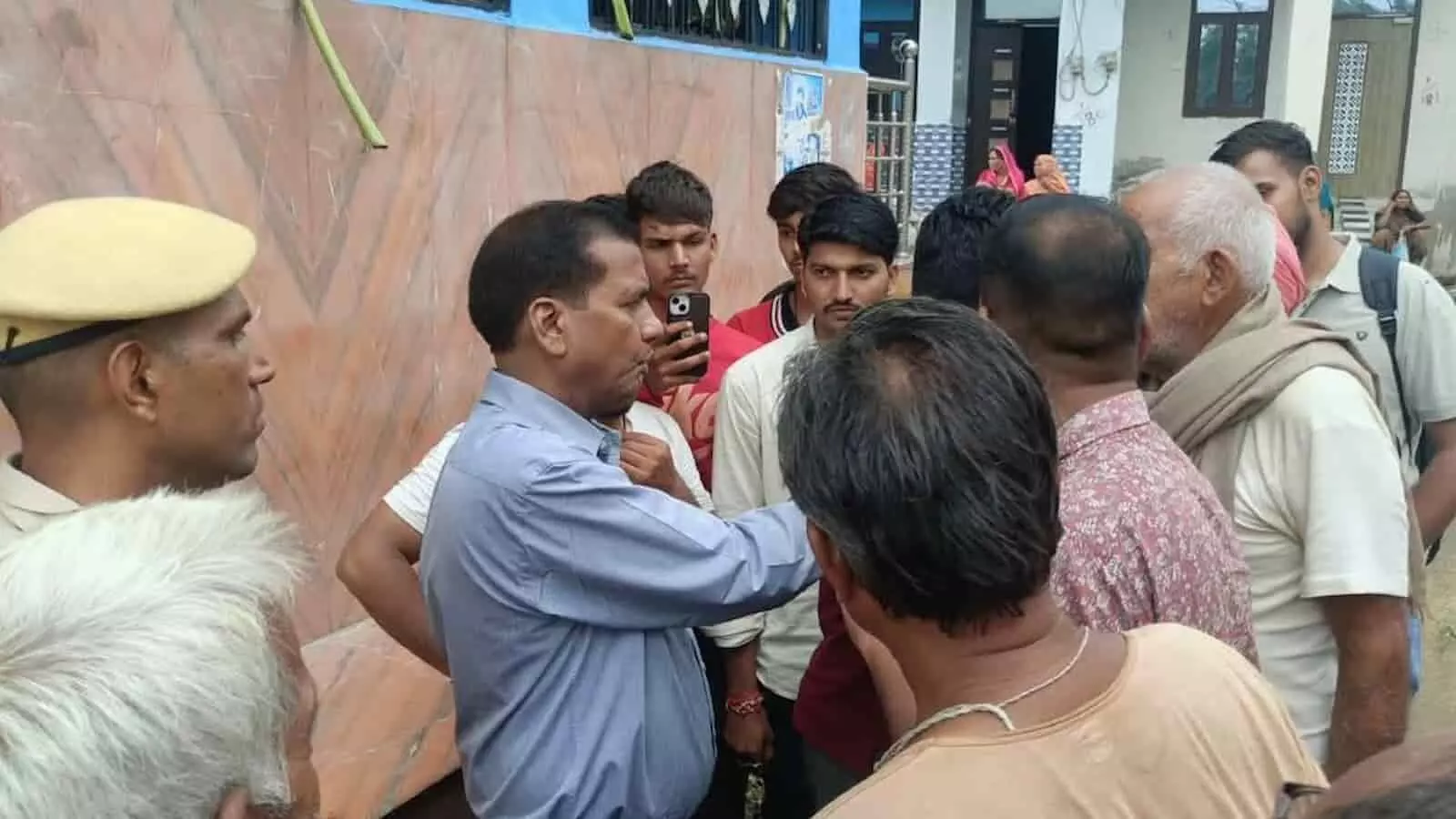 तस्वीर में बाएं एक पुलिसकर्मी, बीच में नीली शर्ट वाले आयुक्त और दाएं खड़े स्थानीय लोग। तस्वीर में बाएं एक पुलिसकर्मी, बीच में नीली शर्ट वाले आयुक्त और दाएं खड़े स्थानीय लोग।