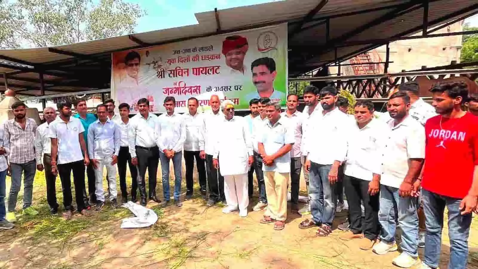 तस्वीर में भीलवाड़ा की गौशाला में कई पुरुष सचिन पायलट के जन्मदिन के बैनर के सामने खड़े हैं। तस्वीर में भीलवाड़ा की गौशाला में कई पुरुष सचिन पायलट के जन्मदिन के बैनर के सामने खड़े हैं।